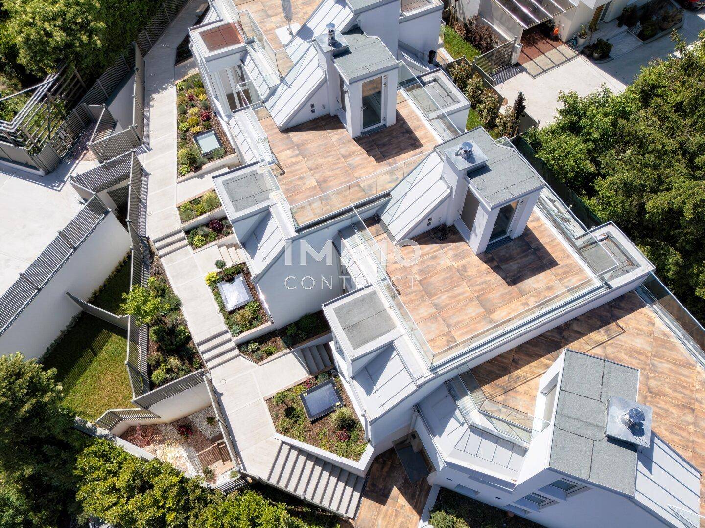 Vogelperspektive auf die Architektur der Reihenhäuser mit Terrassen und Treppenanlagen.