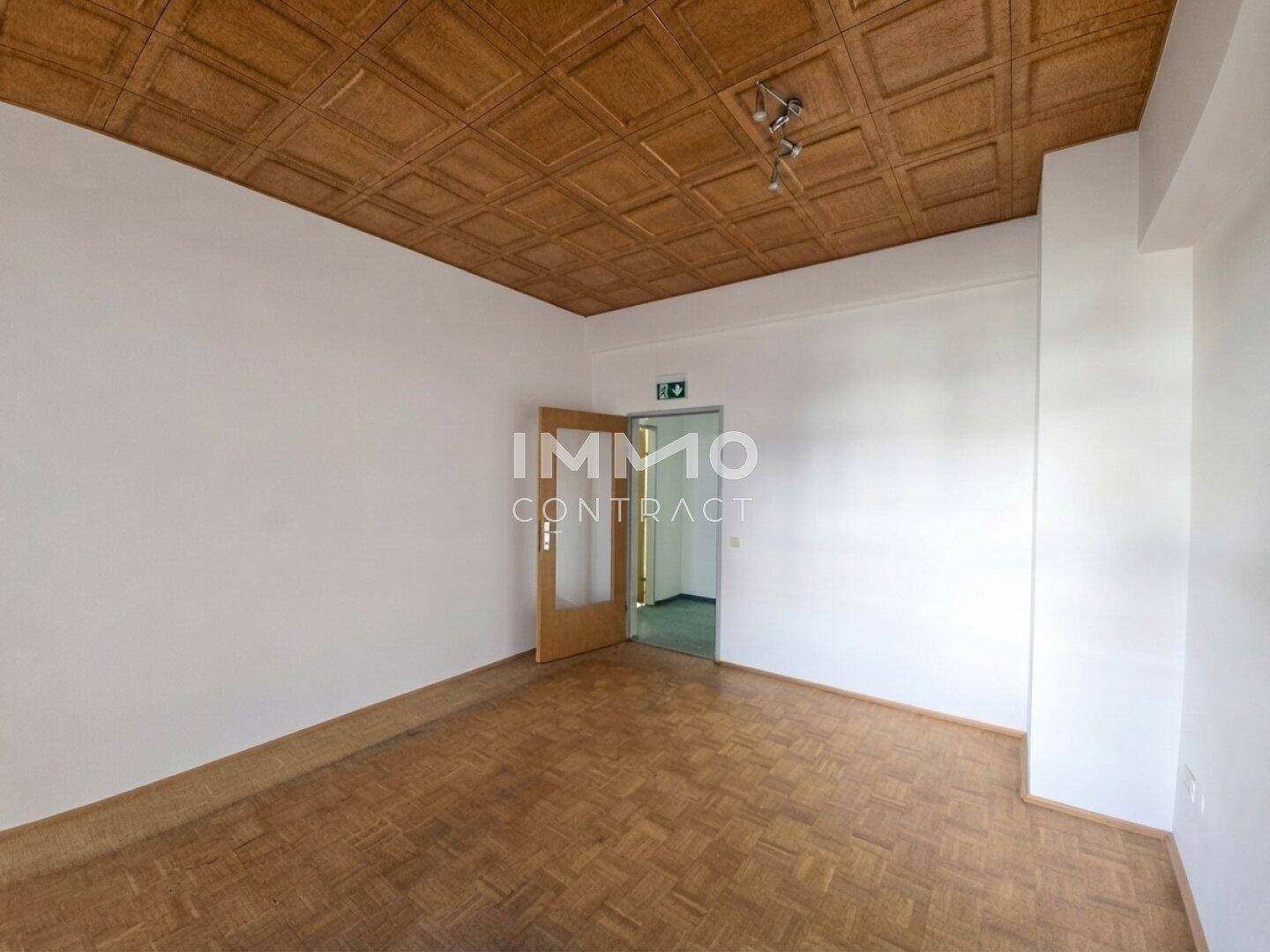 Raum mit charakteristischer Holzkassettendecke und Parkettboden, bietet eine traditionelle Arbeitsatmosphäre.