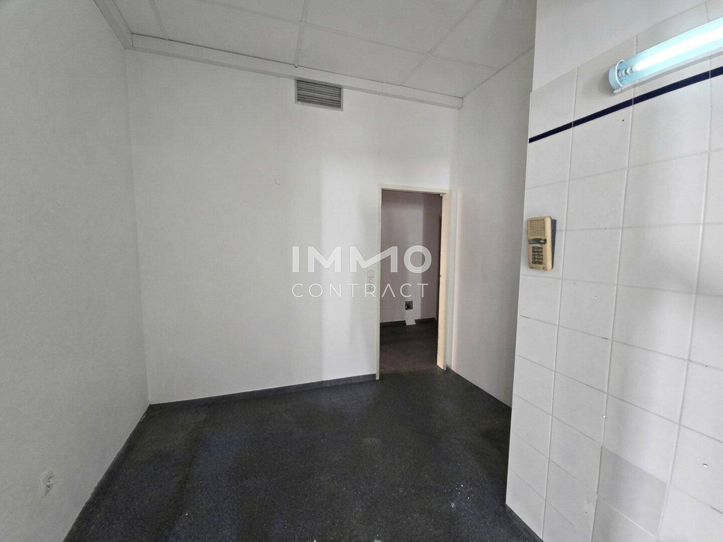 Kleiner Raum mit dunklem Boden und teilweise gefliesten Wänden, geeignet als Abstell- oder Lagerraum.