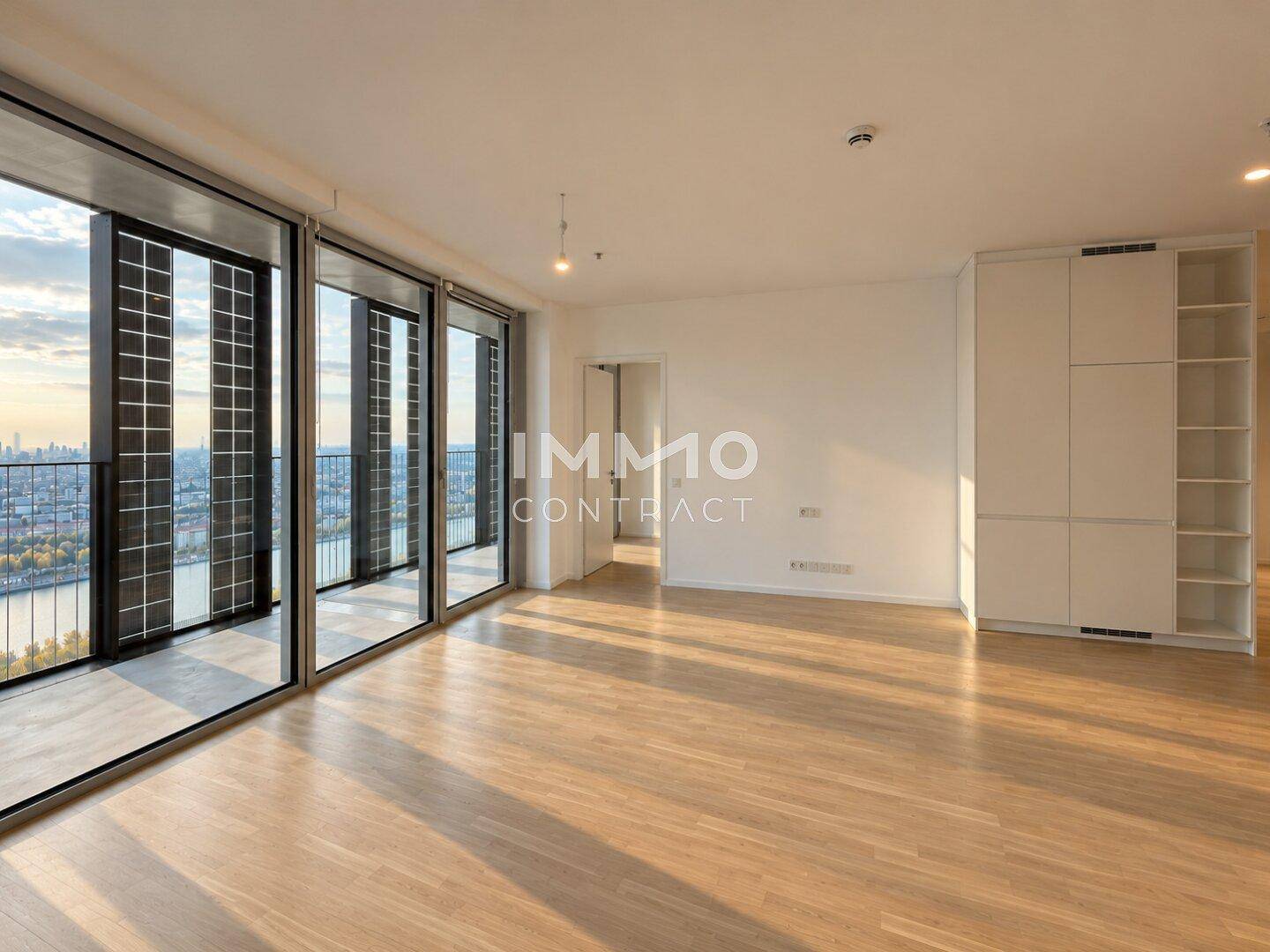 Geräumiger Wohnbereich mit Holzboden und Einbauschränken, bietet einen weiten Blick auf die Stadt.