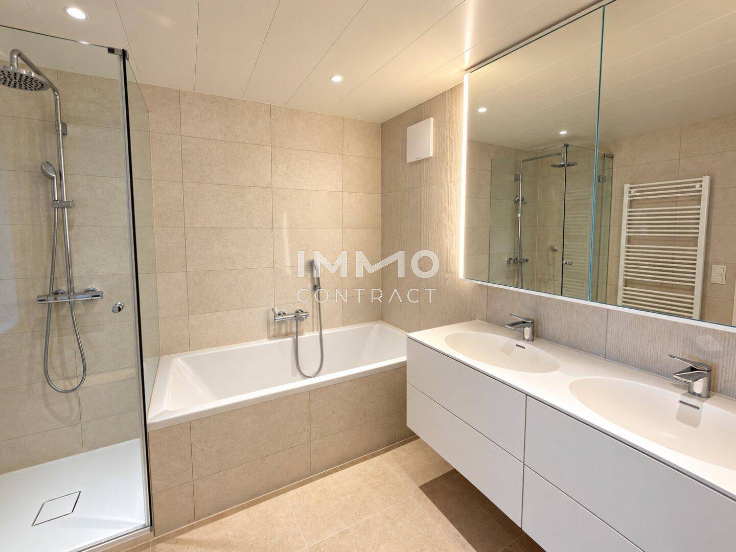 Modernes Badezimmer mit Doppelwaschbecken, Badewanne, Dusche und beheiztem Handtuchhalter.