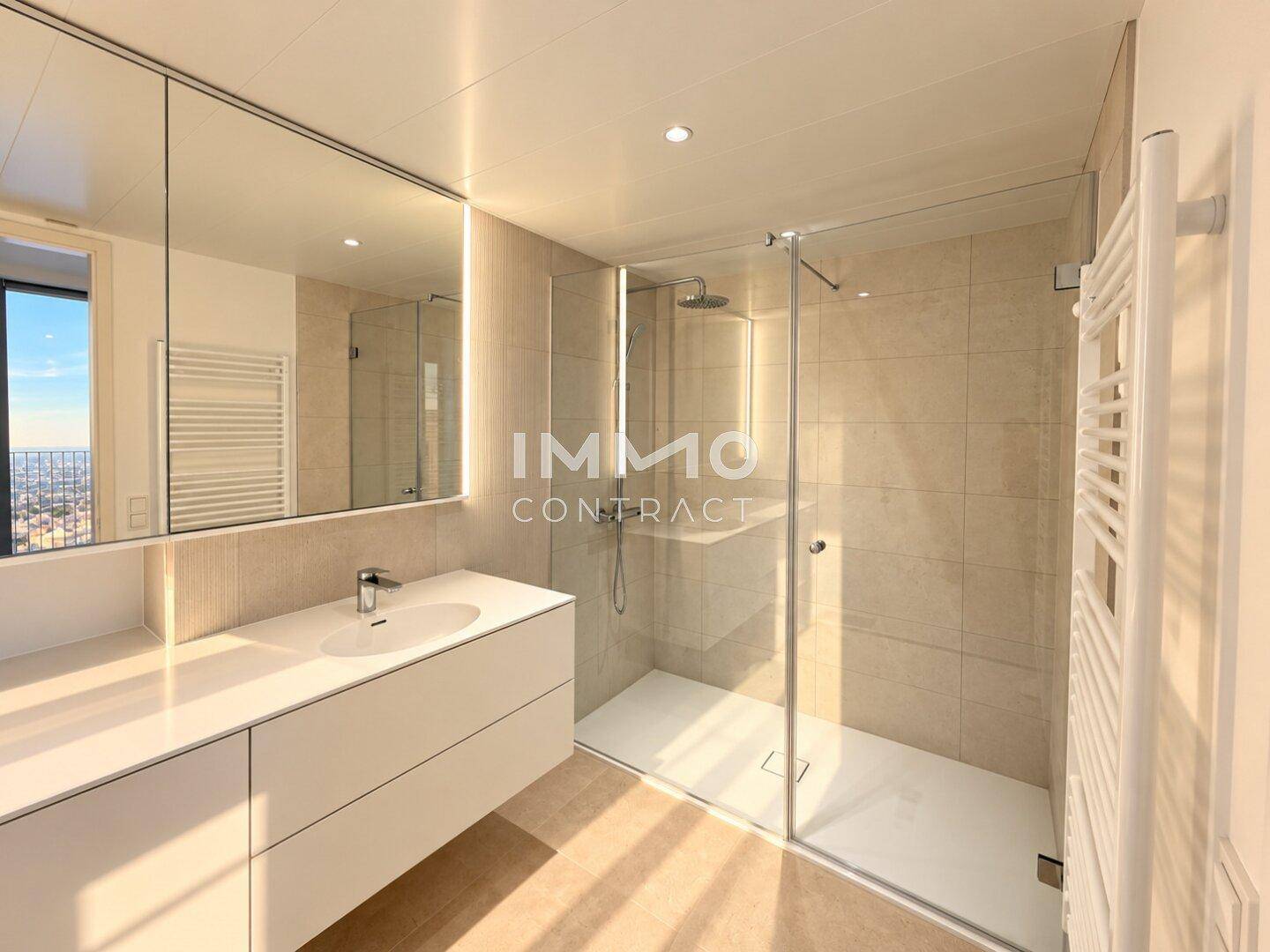 Modernes Badezimmer mit großer begehbarer Dusche, Einzelwaschbecken und beheiztem Handtuchhalter.
