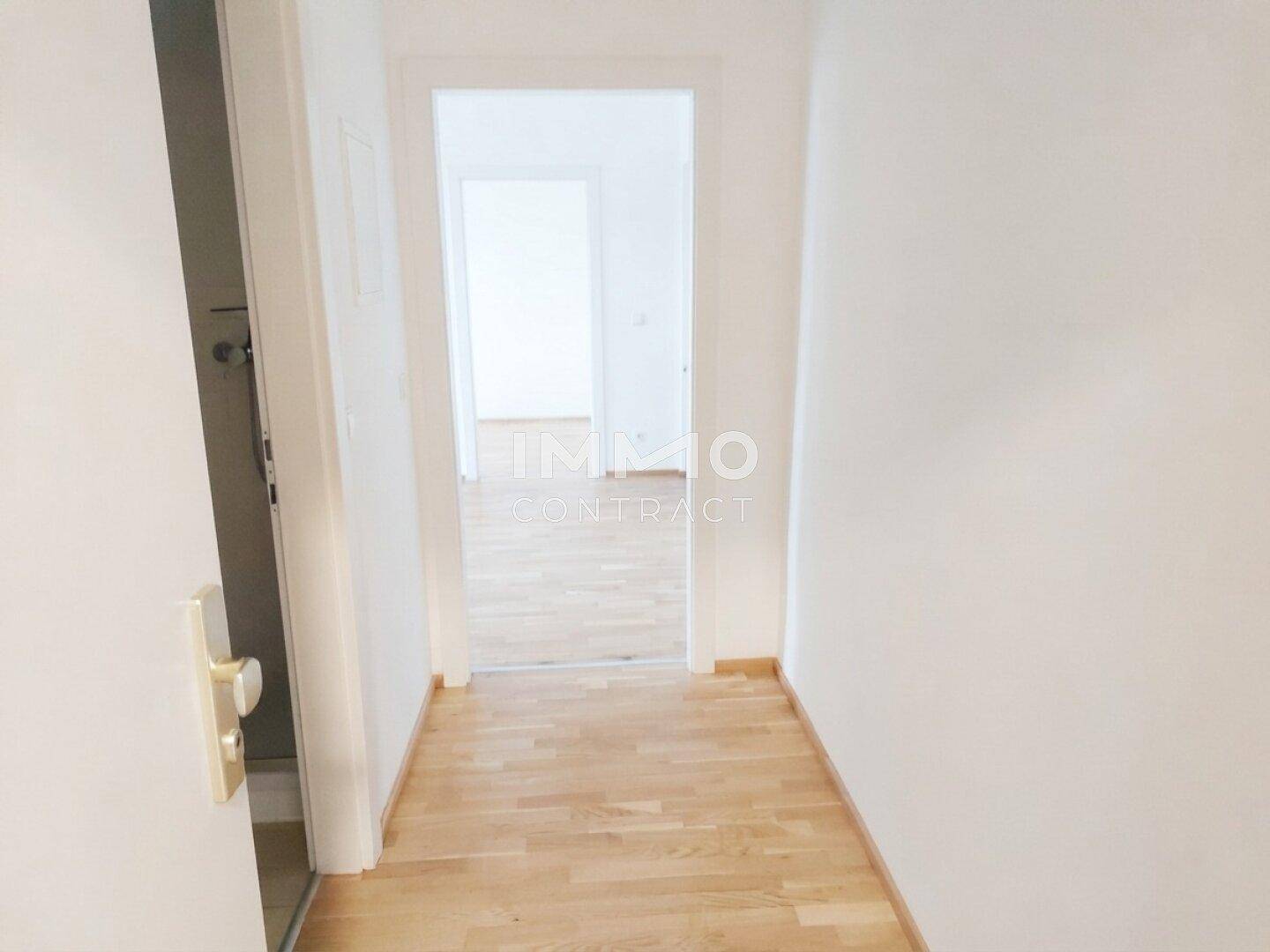 Heller Flur mit Parkettboden, der zu den verschiedenen Zimmern der Wohnung führt.