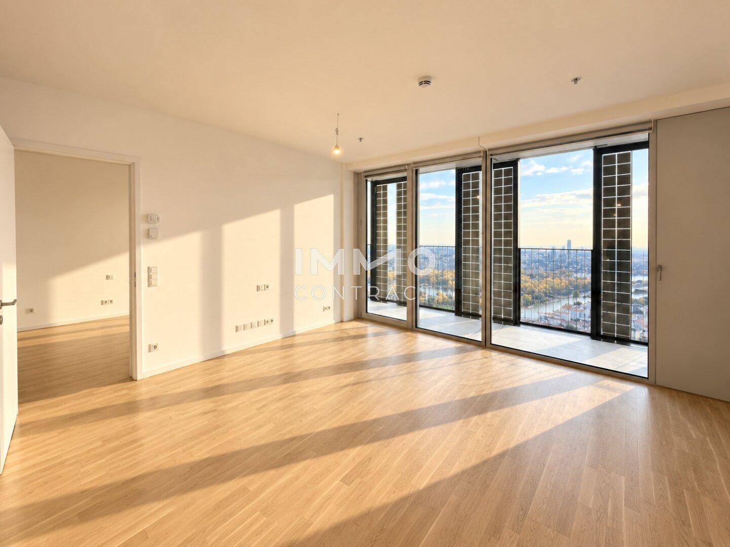 Geräumiges Wohnzimmer mit hellem Parkettboden und bodentiefen Fenstern mit Panoramablick.
