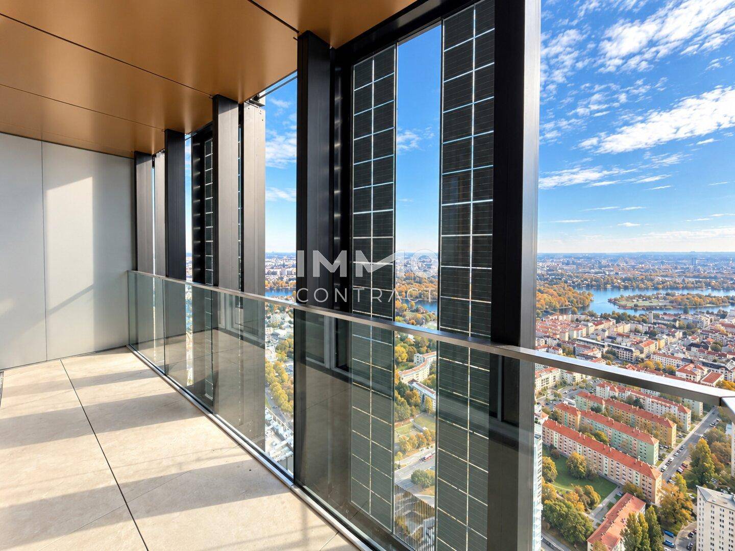 Balkon mit Glasbrüstung und weitem Blick über die Stadt und den Fluss, umgeben von modernen Fassaden.