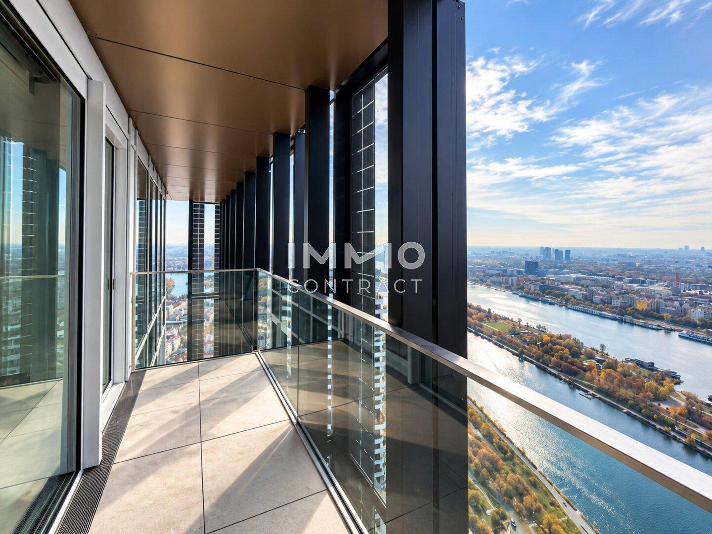 Langer Balkon mit Glasbrüstung und atemberaubendem Blick über die Stadt und den Fluss.