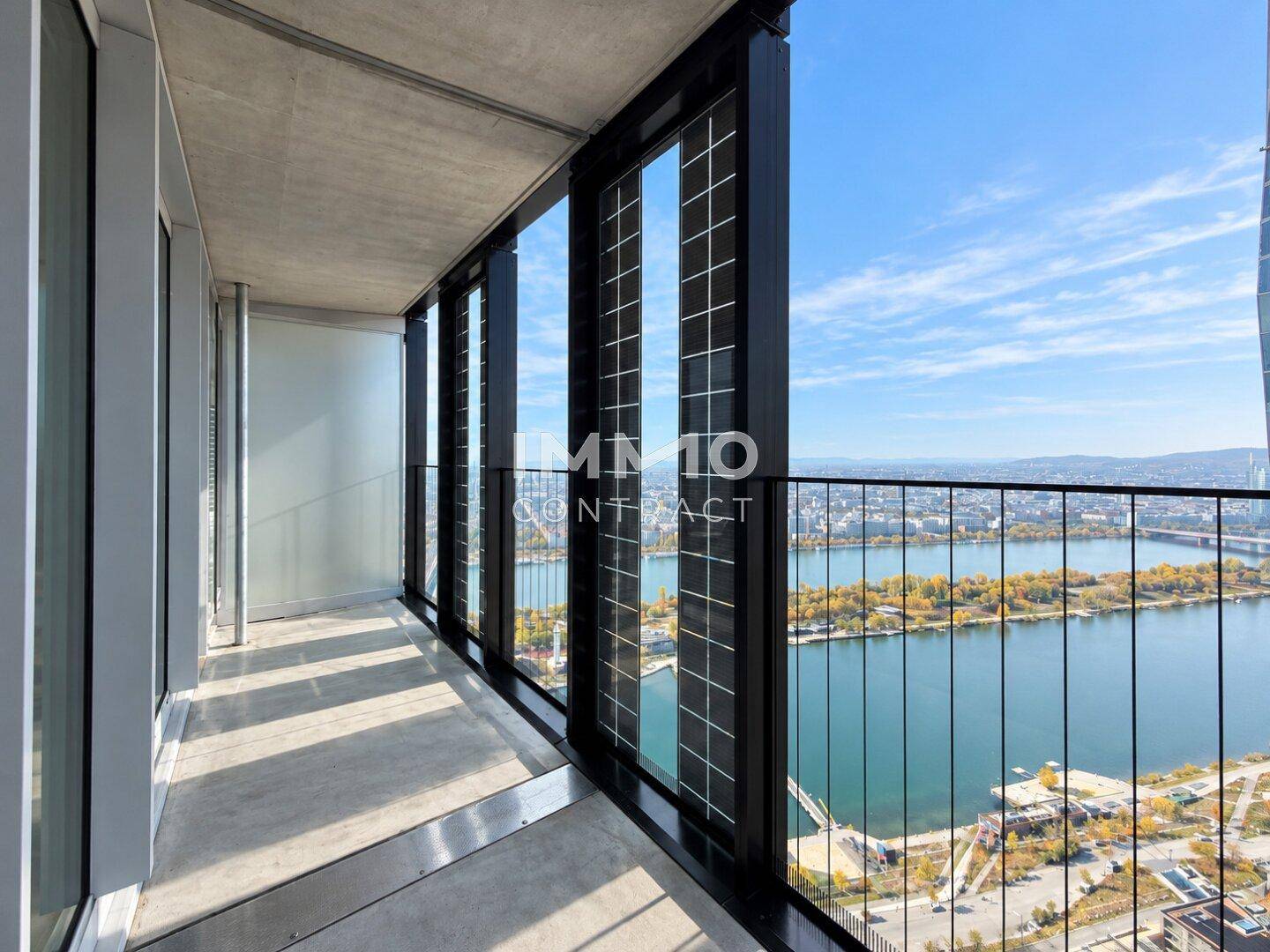 Langer Balkon mit Glasbrüstung und Panoramablick auf den Fluss und die Stadt.