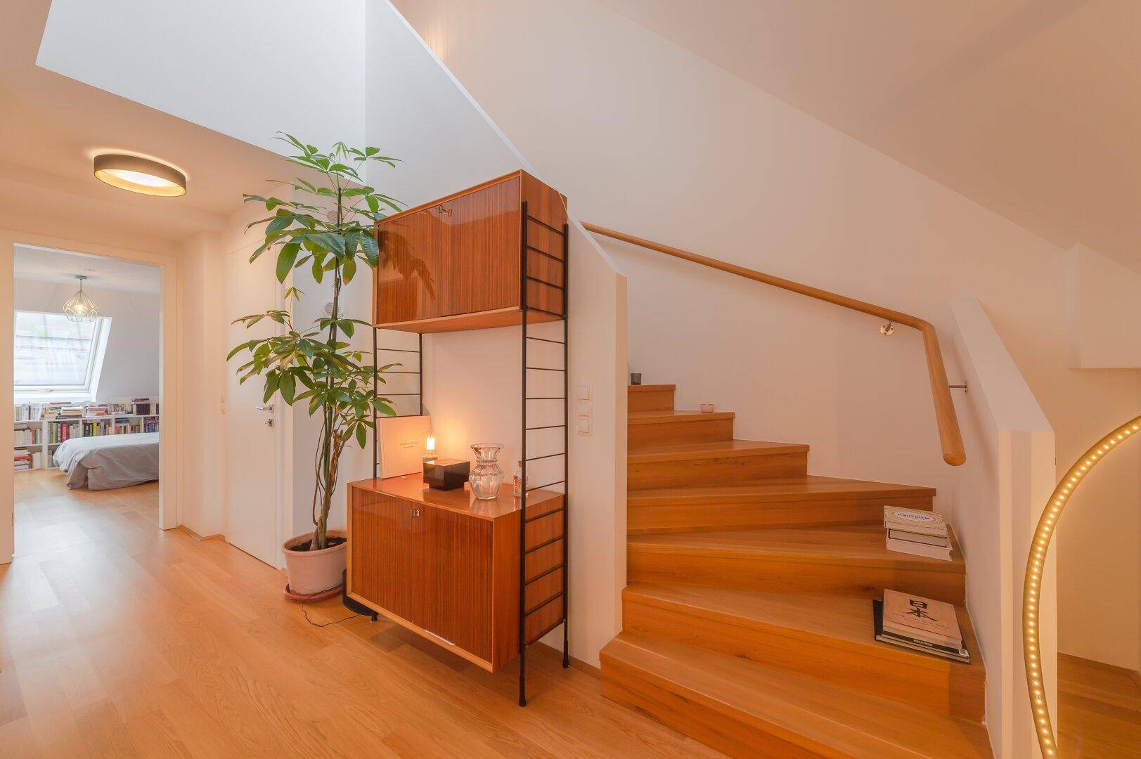 Geräumiger Flur mit Holztreppe, Oberlicht und Zugang zum Schlafzimmer im Dachgeschoss.