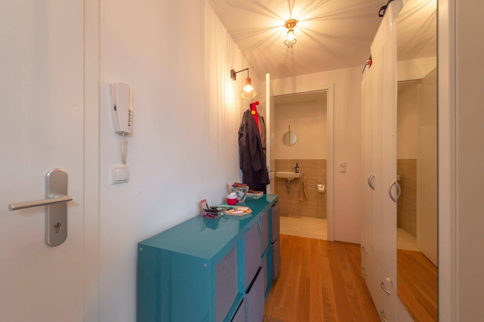 Heller Eingangsbereich mit Garderobe und direktem Zugang zum Gäste-WC.
