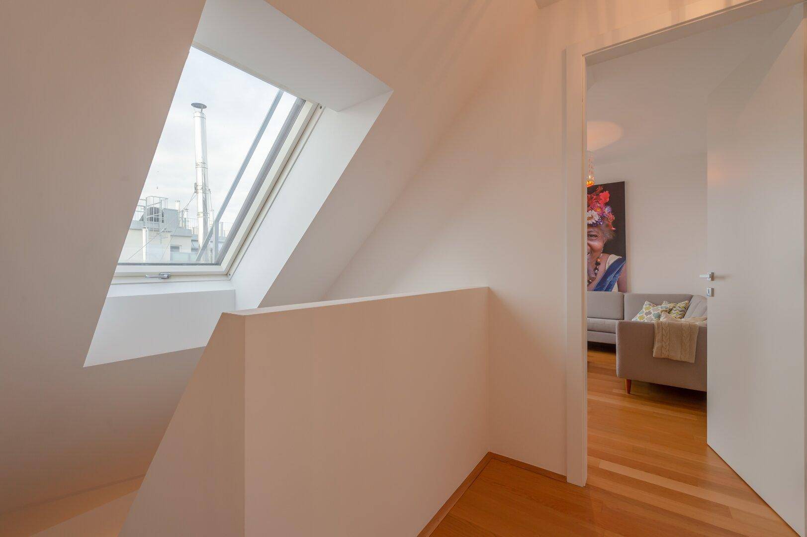 Heller Flur im Dachgeschoss mit Dachfenster und Blick auf den Wohnbereich.
