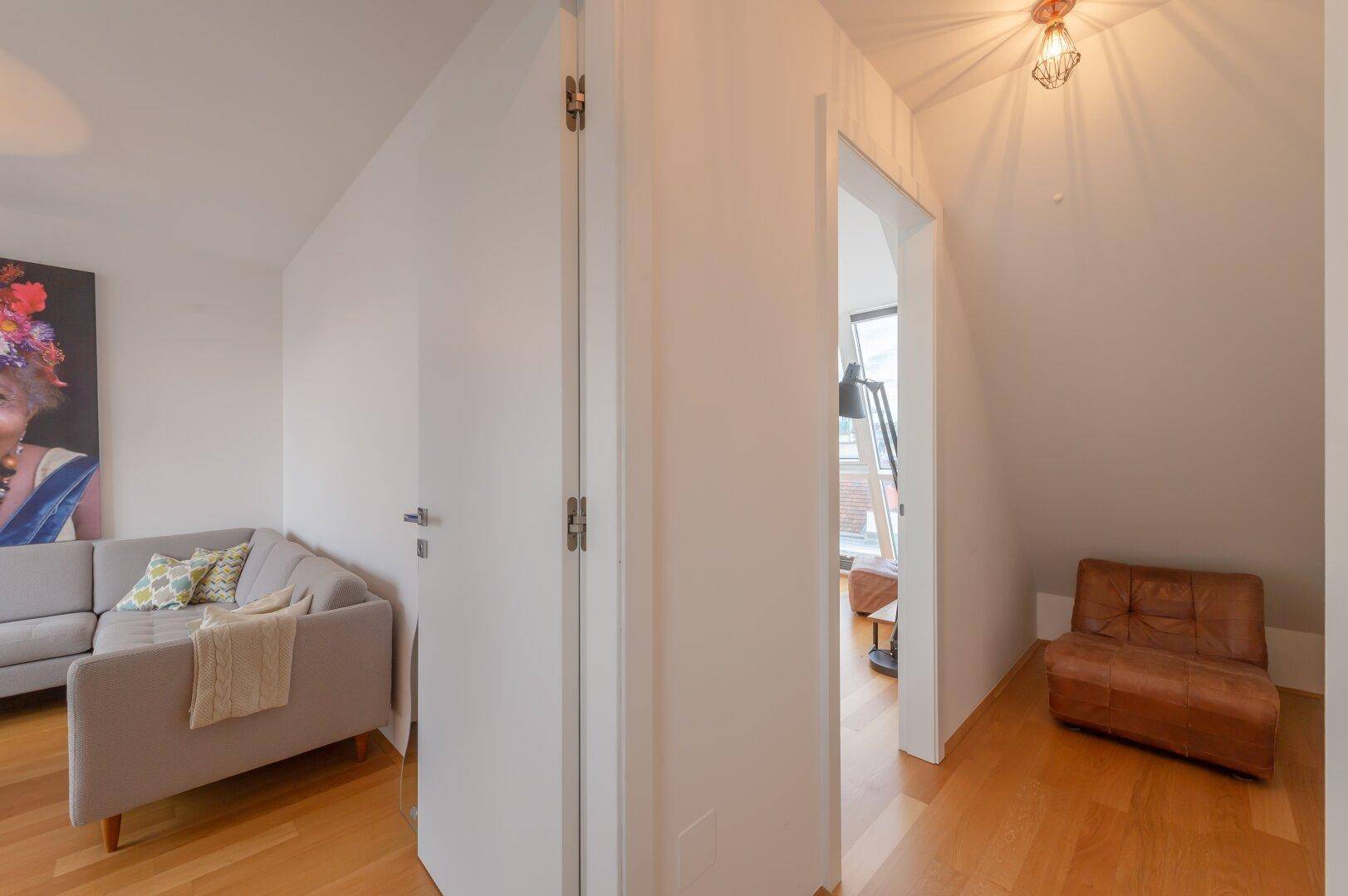 Heller Flur mit Holzboden, der zu einem weiteren Wohnbereich und Schlafzimmer führt.