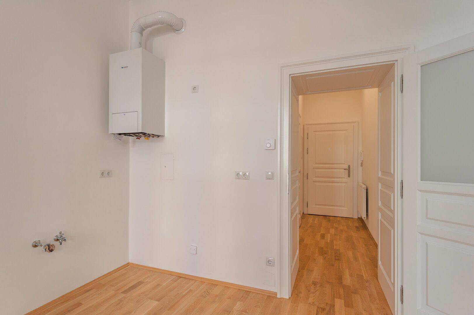 Praktischer Hauswirtschaftsraum mit Gastherme und Anschlüssen, bereit für individuelle Nutzung.