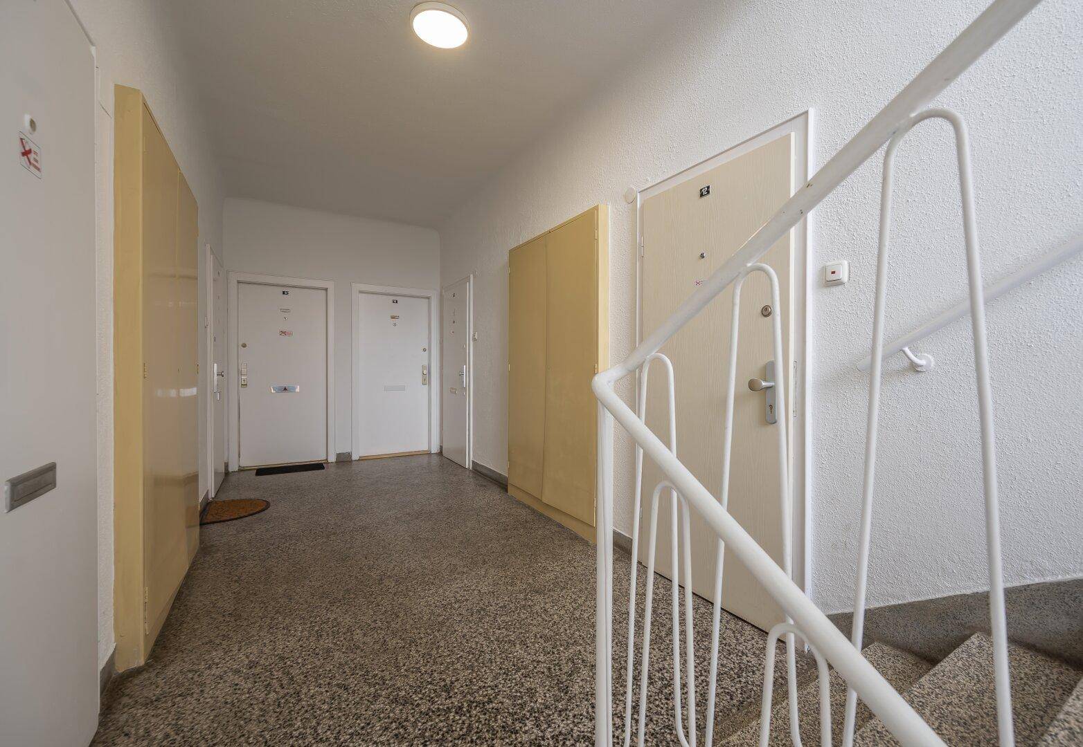 Gemeinschaftlicher Flur mit Treppenhaus und Zugang zu den Wohnungen.