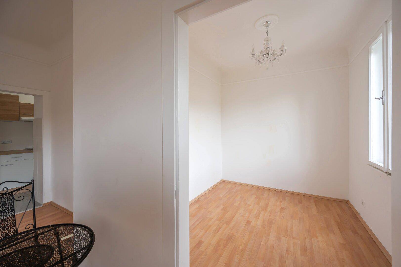 Leeres Zimmer mit Laminatboden, ideal als Schlaf- oder Arbeitszimmer.