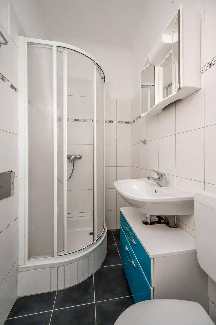 Modernes Badezimmer mit Duschkabine, Waschbecken und WC.