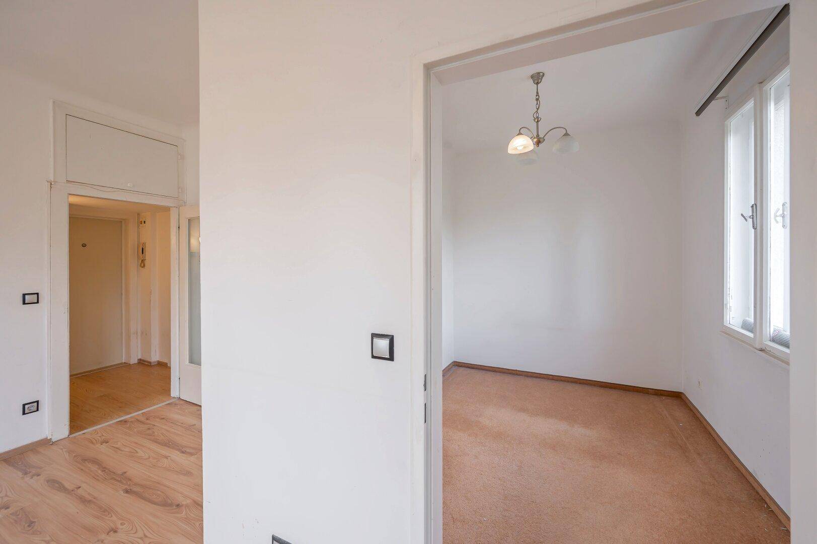 Heller Flur mit Laminatboden, der zu weiteren Zimmern der Wohnung führt.