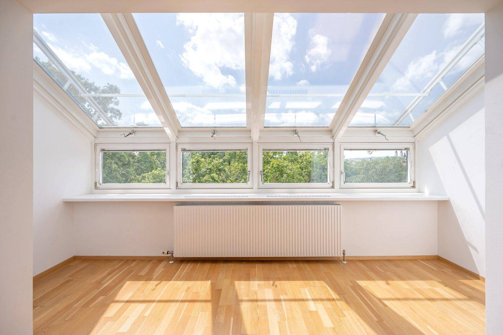 Große Dachfenster und normale Fenster bieten einen weiten Blick ins Grüne und viel Tageslicht.