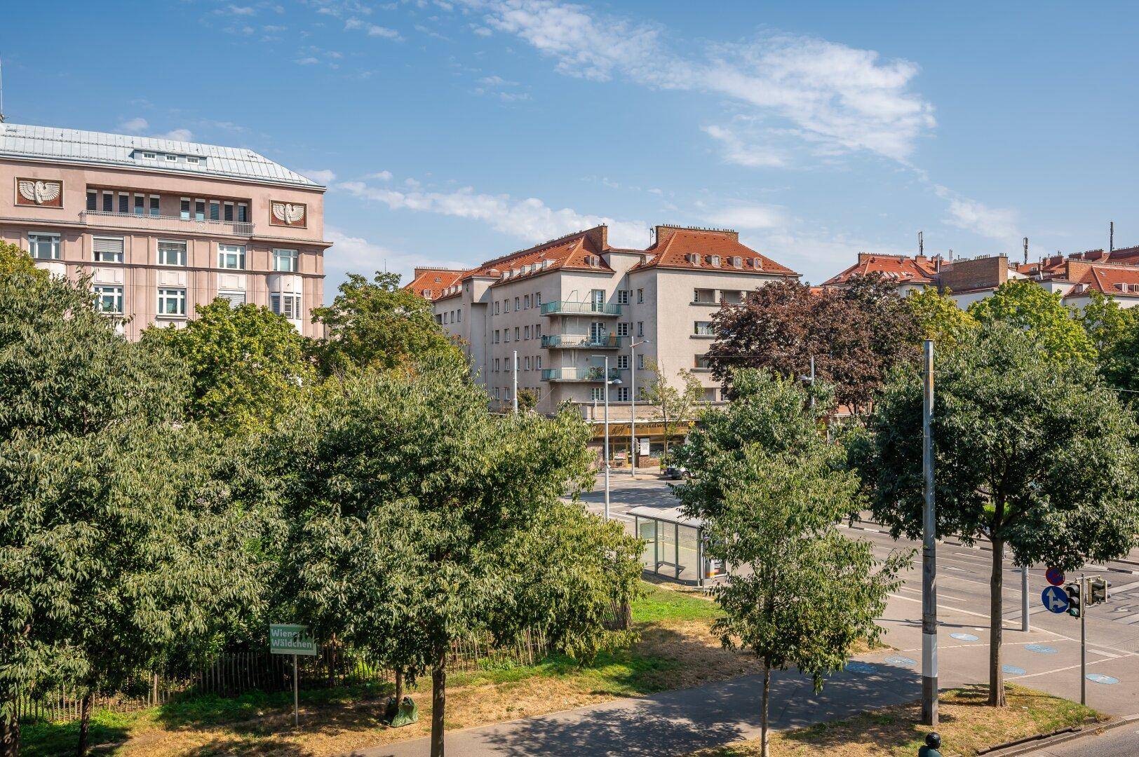Weitläufiger Blick über die Stadt mit viel Grün und urbaner Bebauung.