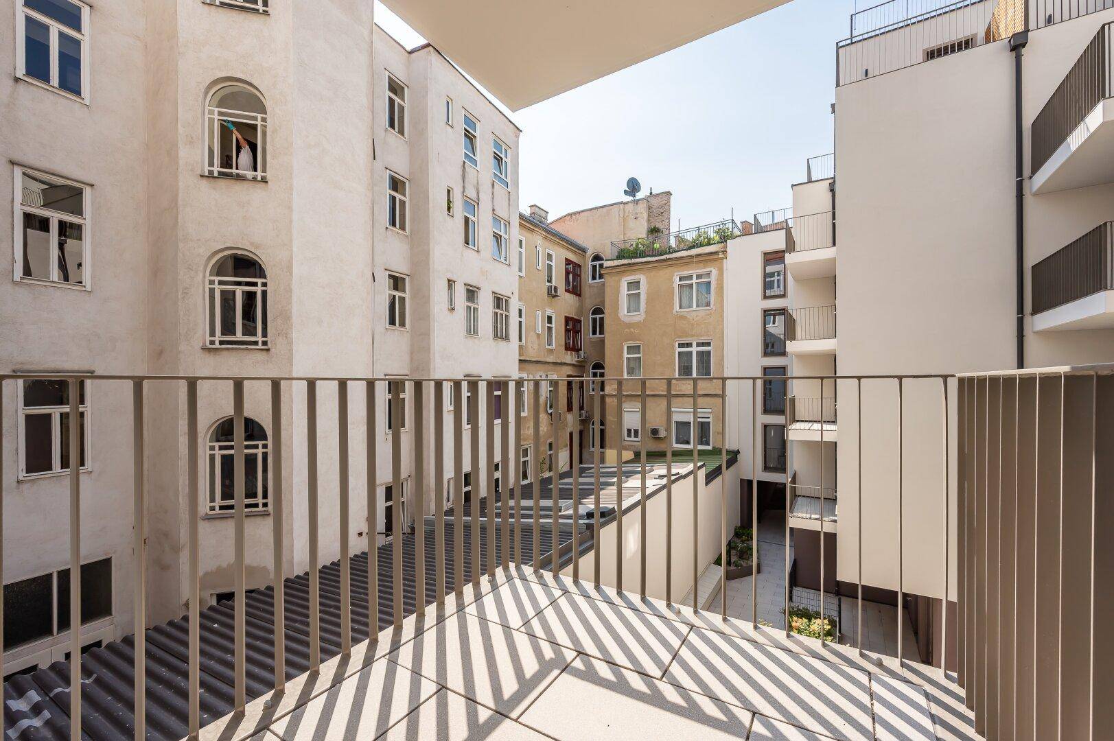 Balkon mit Blick auf den Innenhof und die umliegenden Wohngebäude.
