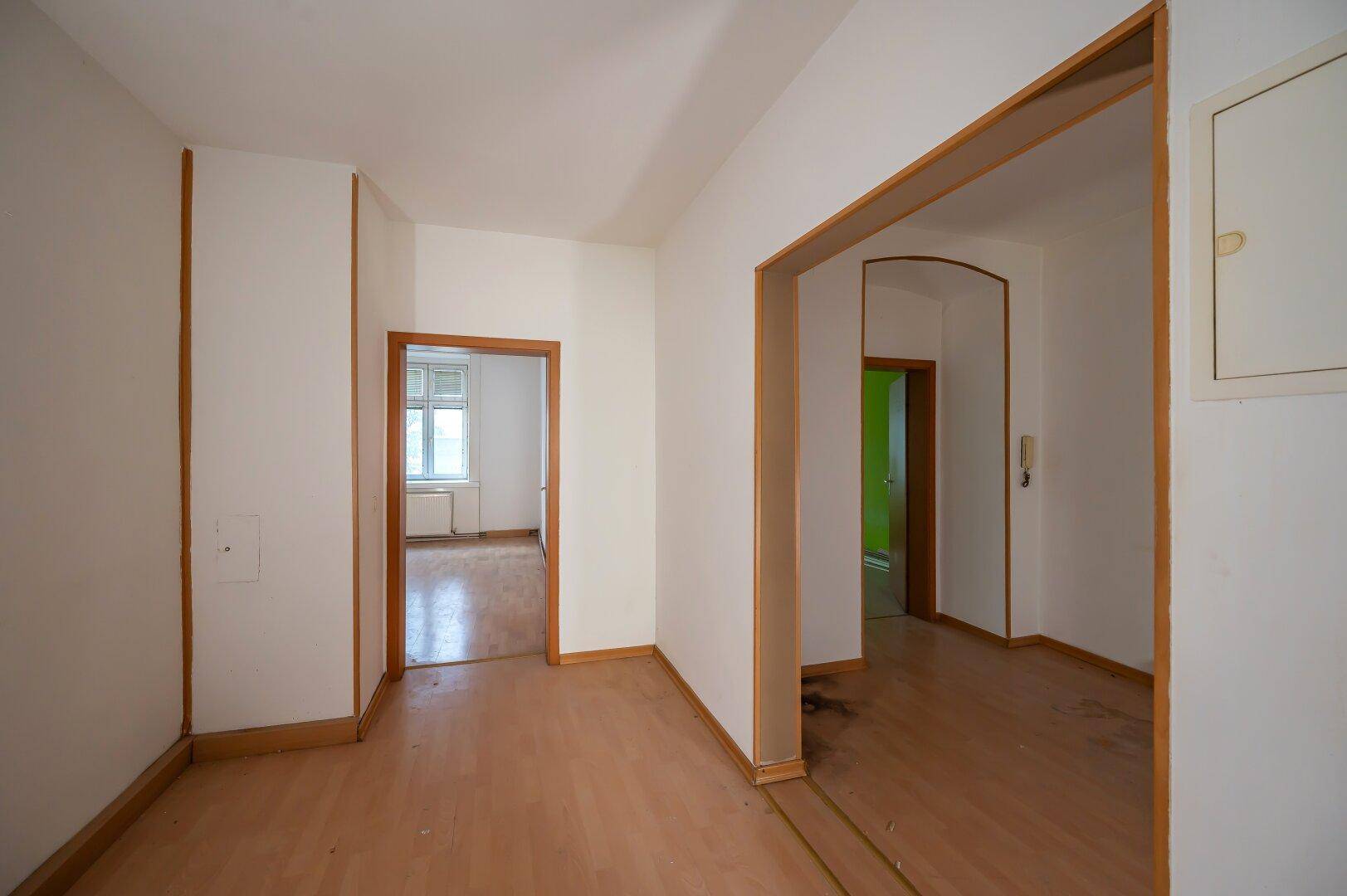Heller Flur mit Holzboden und mehreren Türen, verbindet die Wohnbereiche der Wohnung.