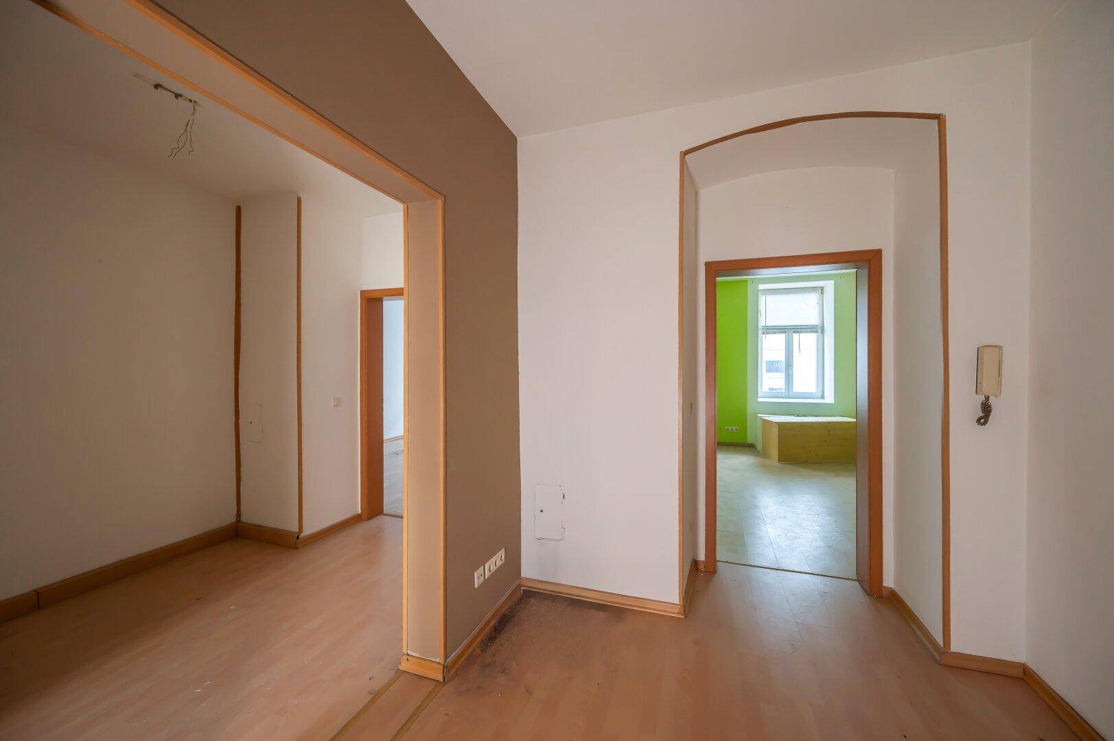 Geräumiger Flur mit Holzboden und mehreren Türöffnungen, verbindet verschiedene Zimmer.