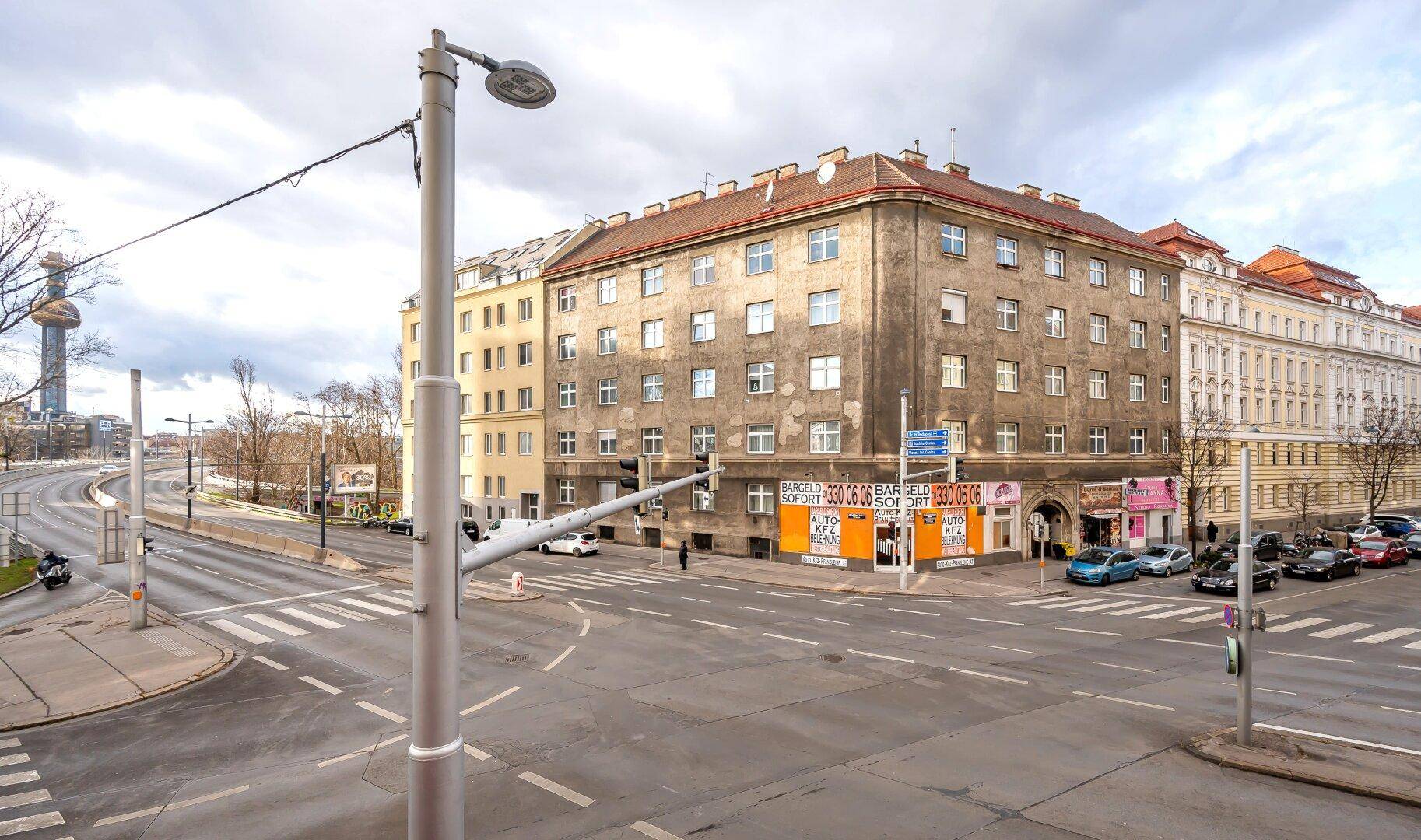 Stadtansicht mit Gebäuden, Straßenkreuzung und bewölktem Himmel, zeigt die Umgebung des Objekts.