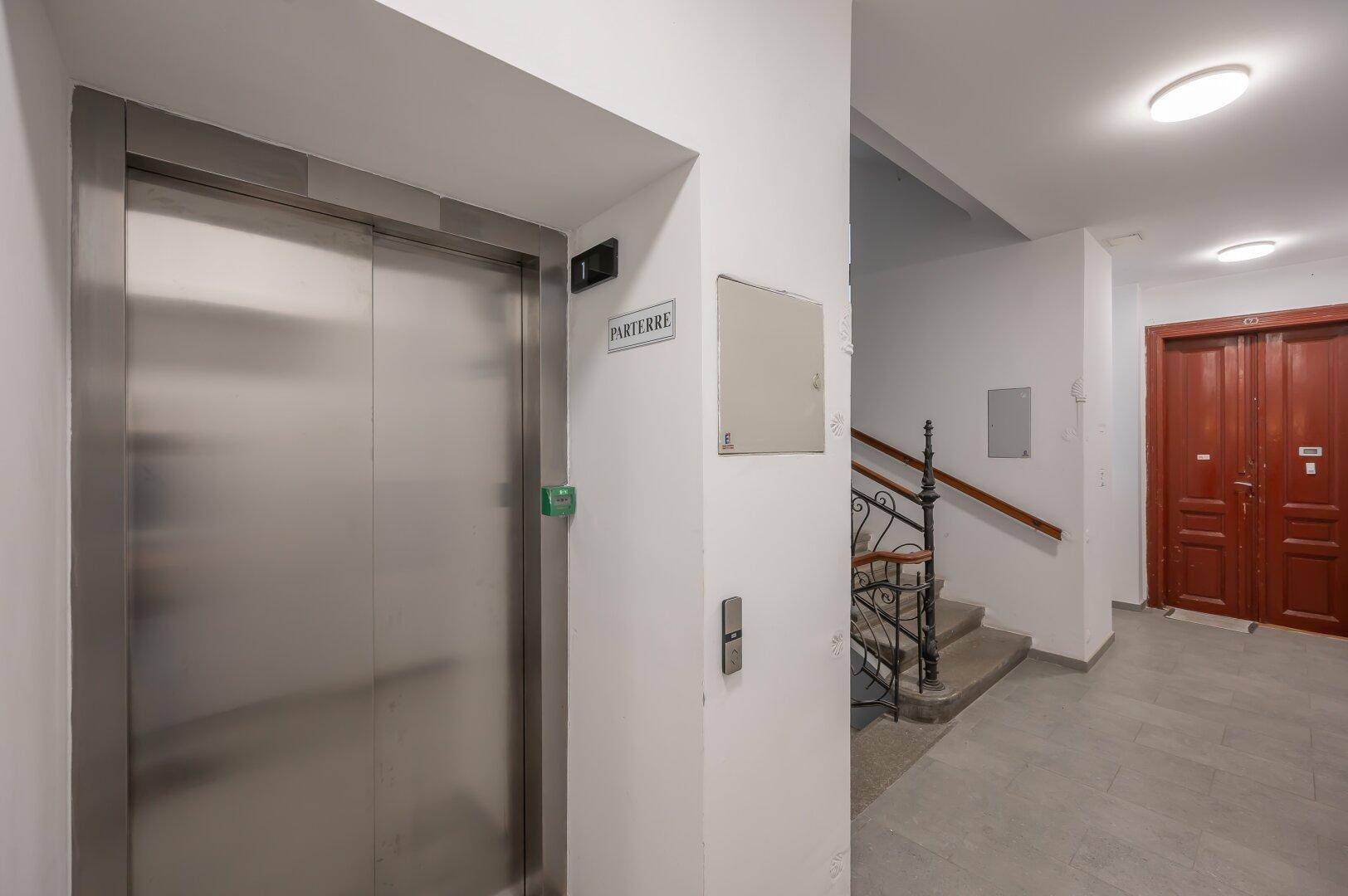Moderner Aufzug und Treppenhaus im Eingangsbereich des Gebäudes mit Zugang zu den Wohnungen.