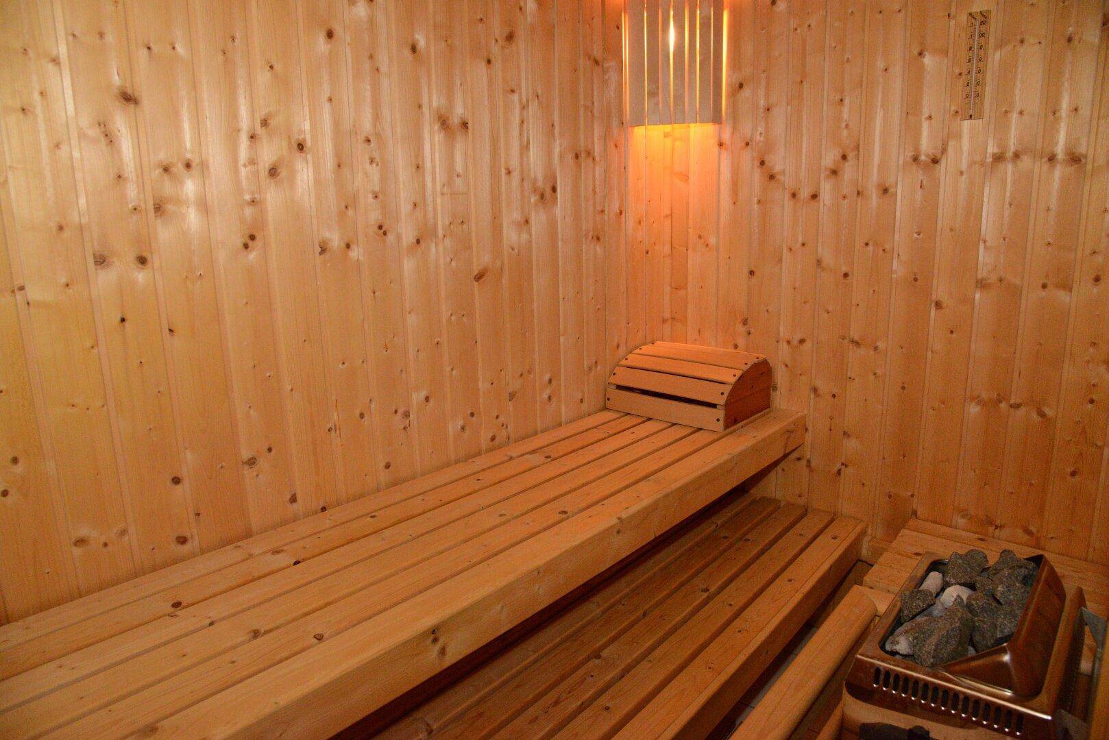 Private Sauna mit Holzverkleidung und Bänken für entspannende Momente.