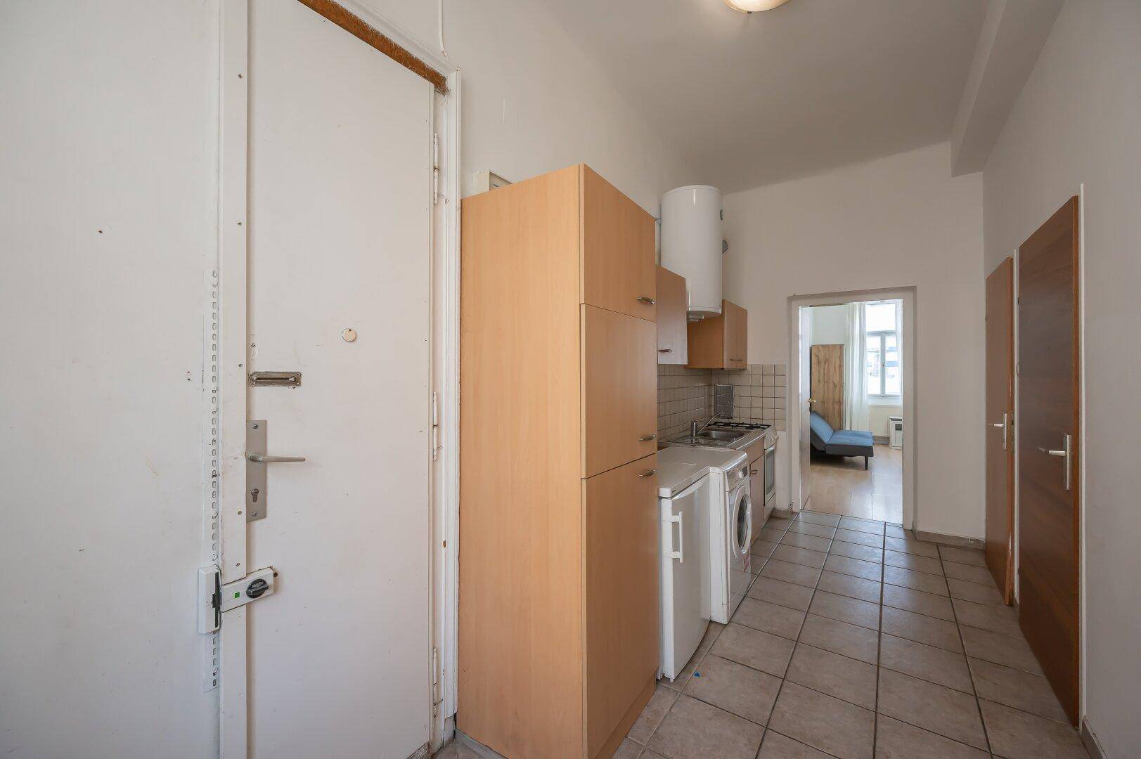 Eingangsbereich mit Sicherheitstür, angrenzender Küchenzeile und Blick in weitere Räume.