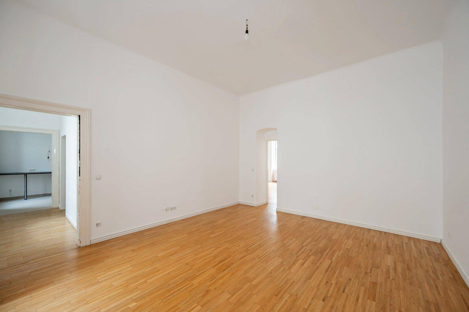 Geräumiger, leerer Raum mit Holzboden und hohen Decken, ideal für flexible Nutzung.
