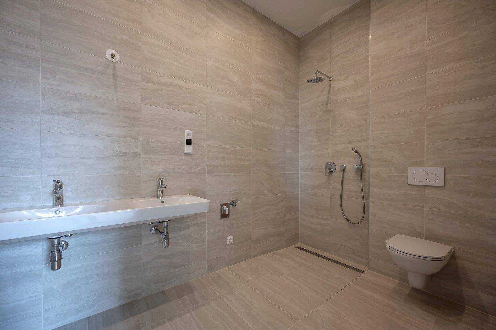 Modernes Badezimmer mit Doppelwaschbecken, bodengleicher Dusche und Wand-WC.