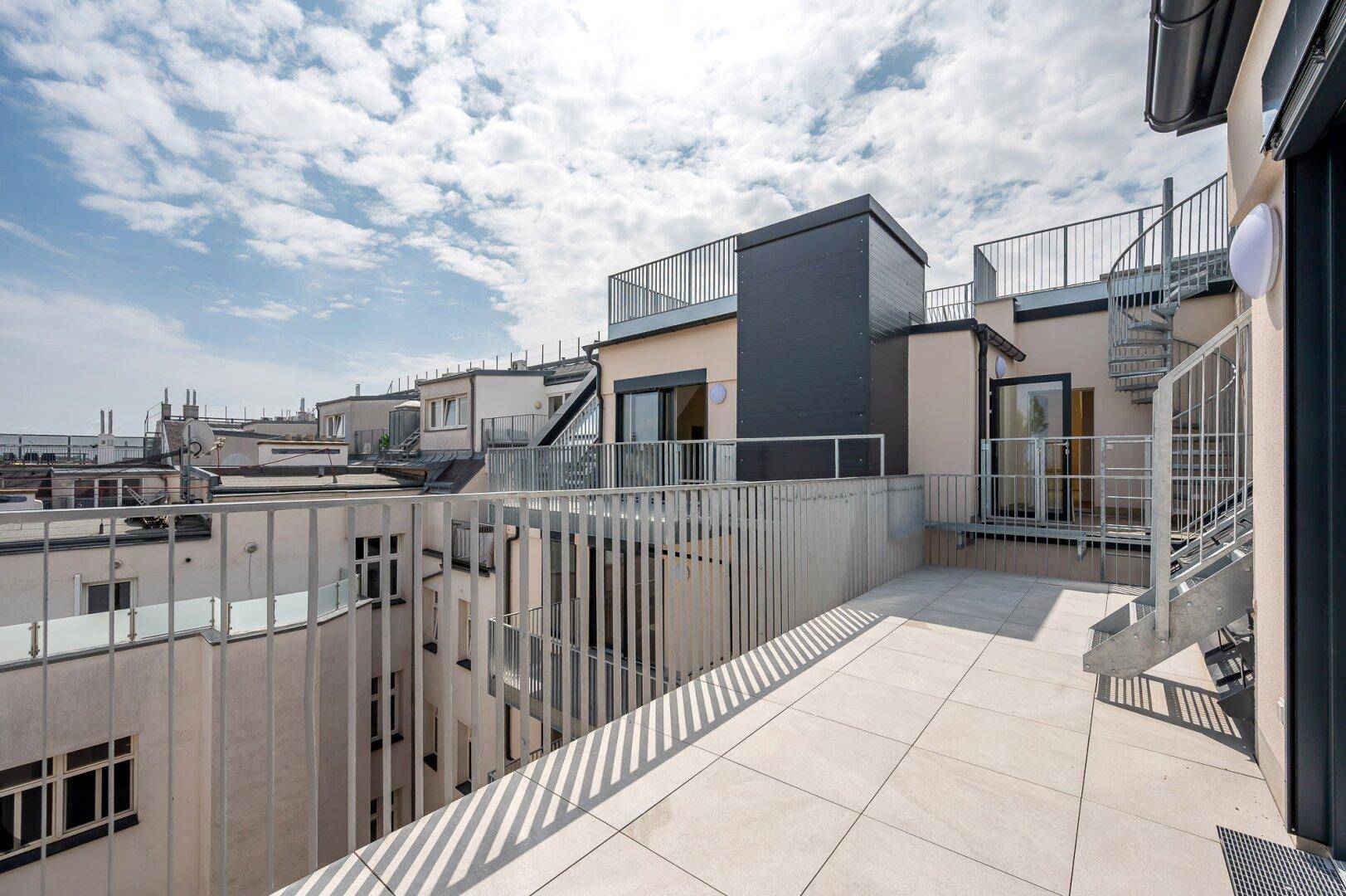 Moderne Dachterrasse mit weitem Blick über die Stadt und angrenzendem Gebäude.