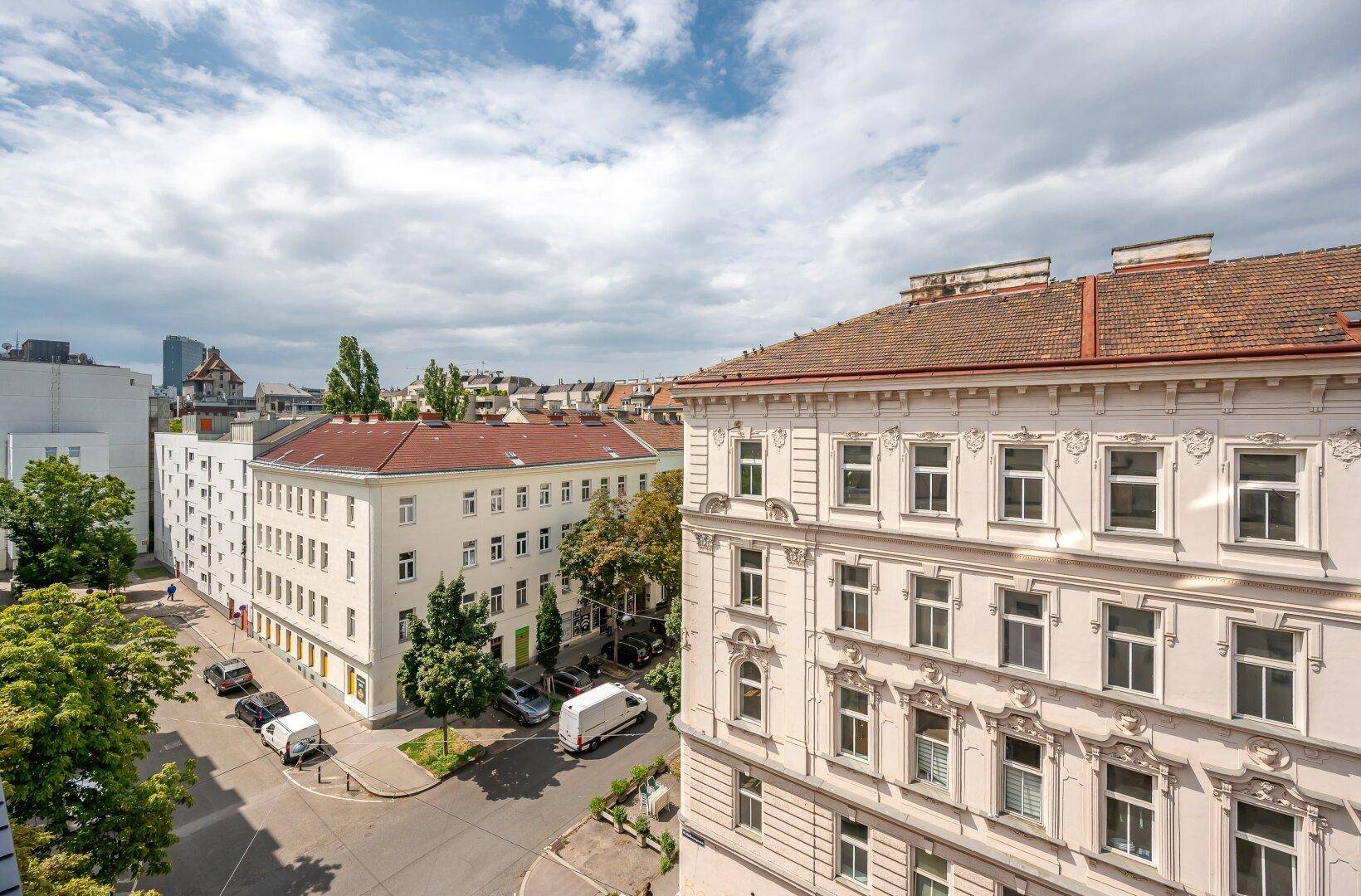 Stadtansicht mit einer Mischung aus Alt- und Neubauten unter bewölktem Himmel.