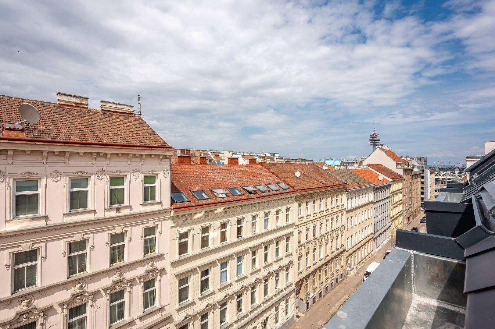 Panoramablick über die Dächer der Stadt mit historischen Gebäuden und einem weiten Himmel.