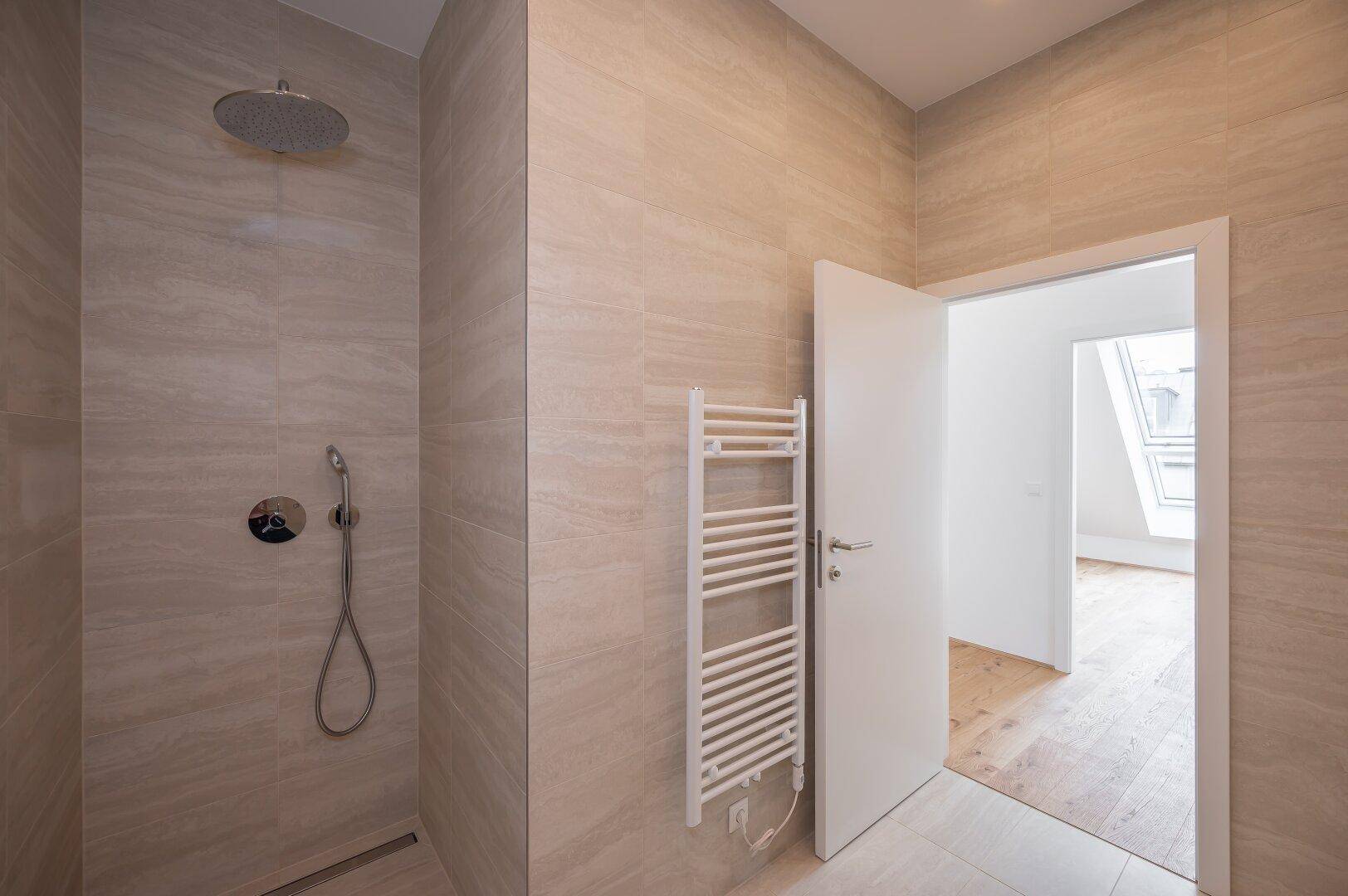 Elegantes Badezimmer mit begehbarer Dusche, Regendusche und beheiztem Handtuchhalter.