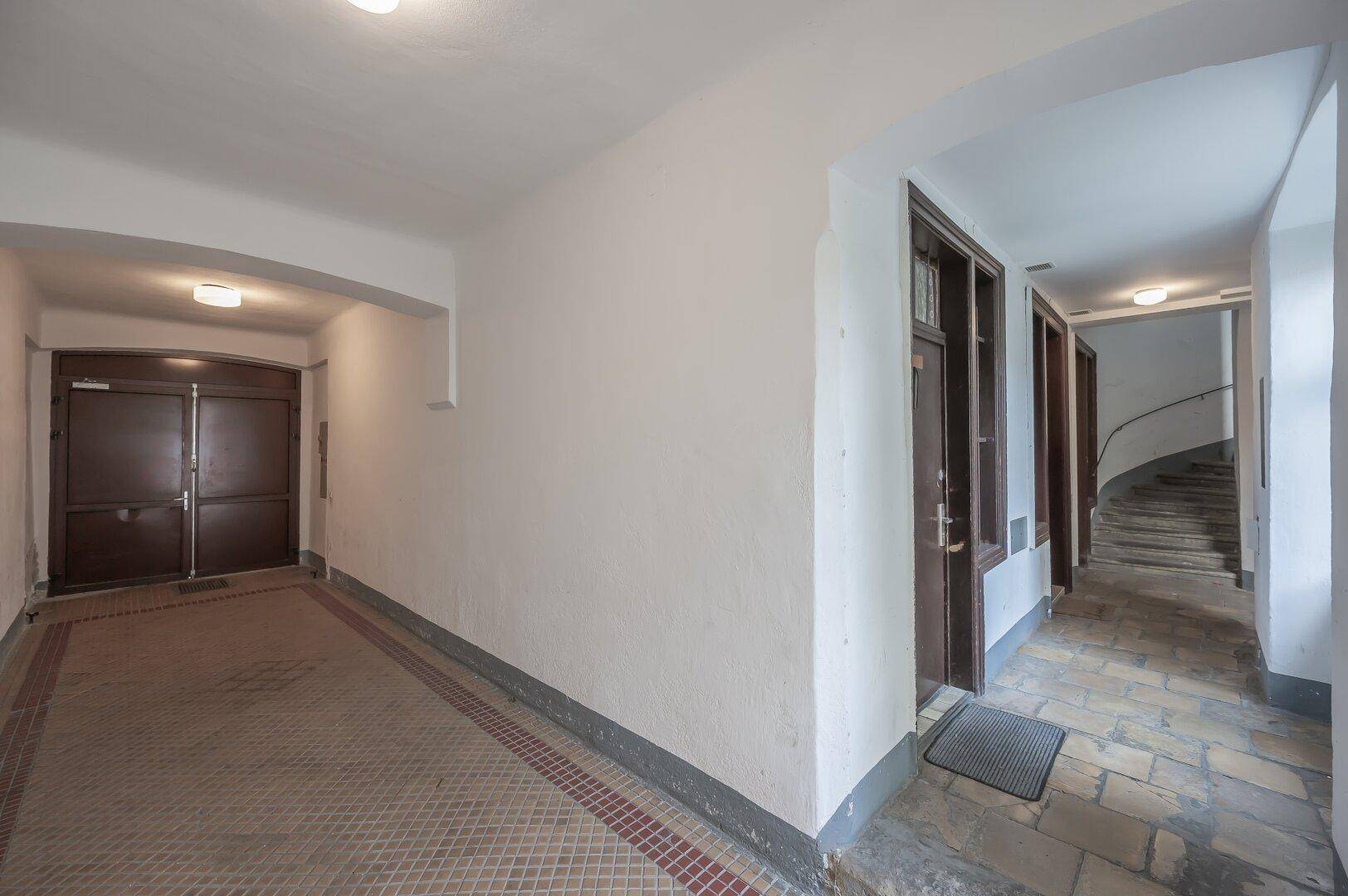 Geräumiger Eingangsbereich mit gemustertem Fliesenboden und Zugang zum Treppenhaus.