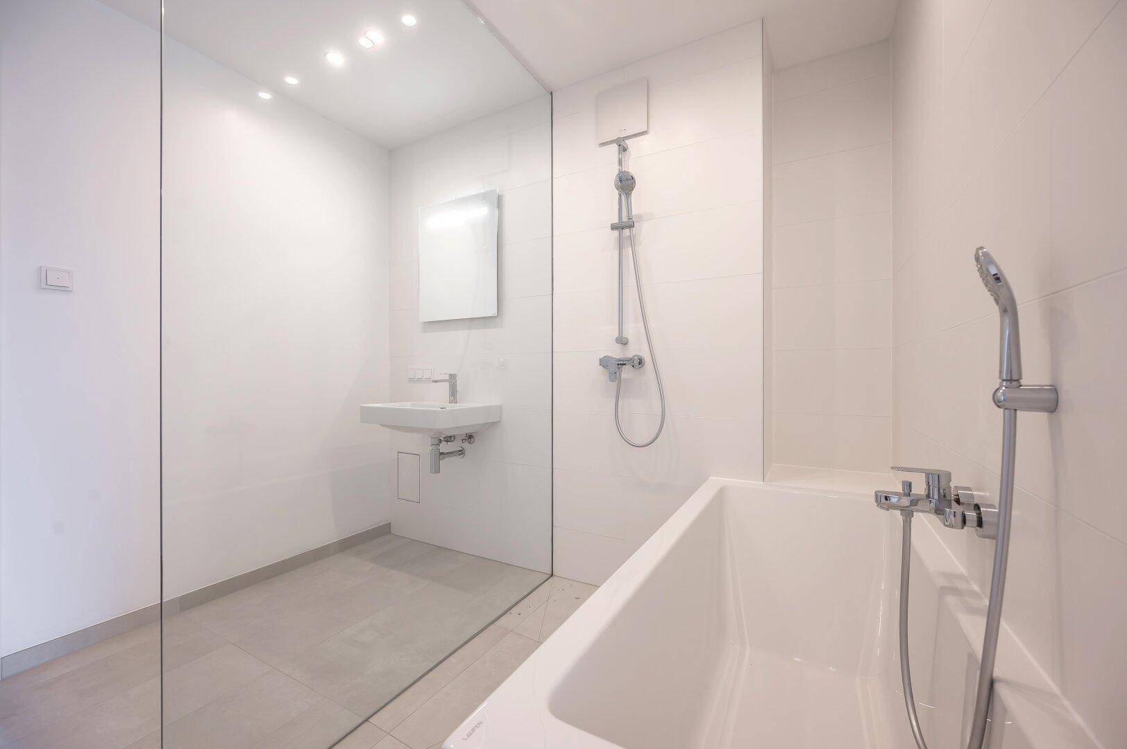 Modernes Badezimmer mit Badewanne, Dusche und Waschbecken.
