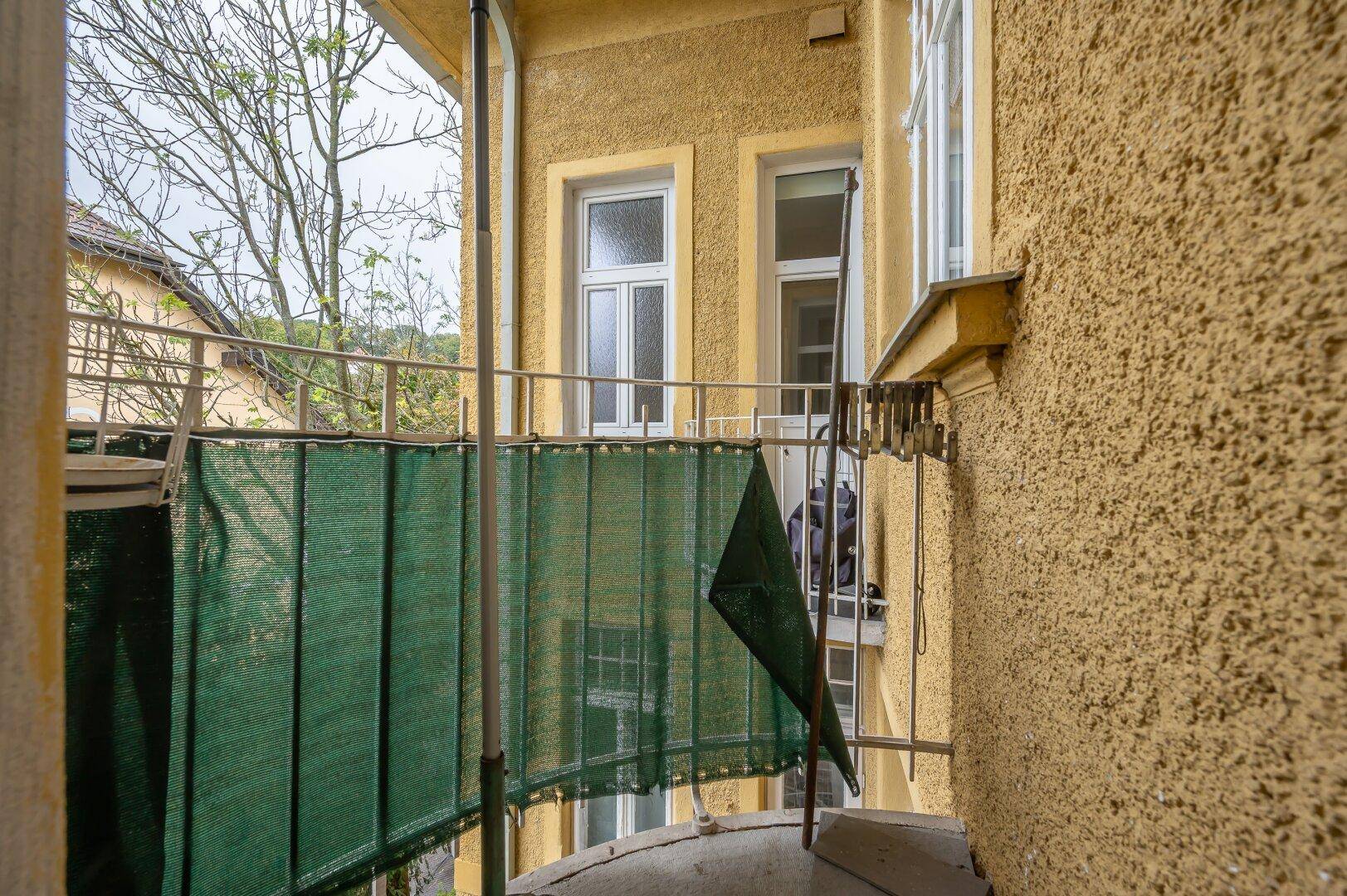 Kleiner Balkon mit Sichtschutz und Blick auf die umliegenden Gebäude.