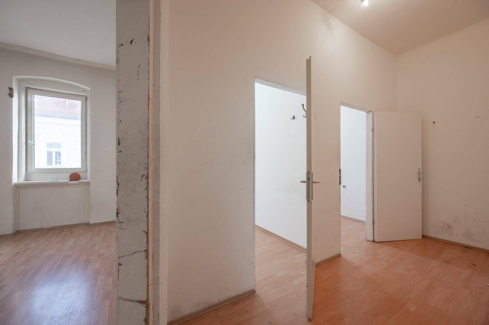 Geräumiger Flur mit Laminatboden und mehreren Türen, der zu verschiedenen Räumen führt.