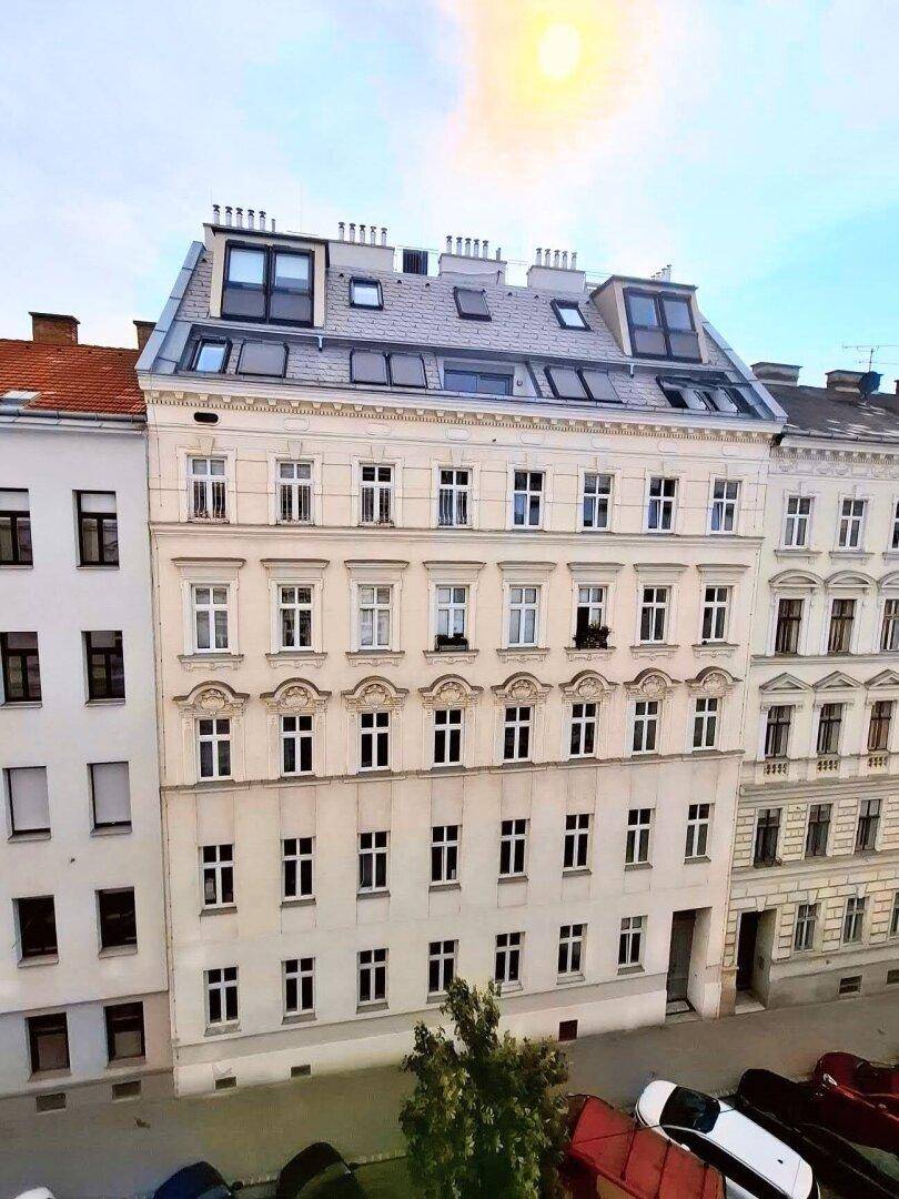 Historisches Gebäude mit Mansarddach und vielen Fenstern, prägt das Stadtbild.
