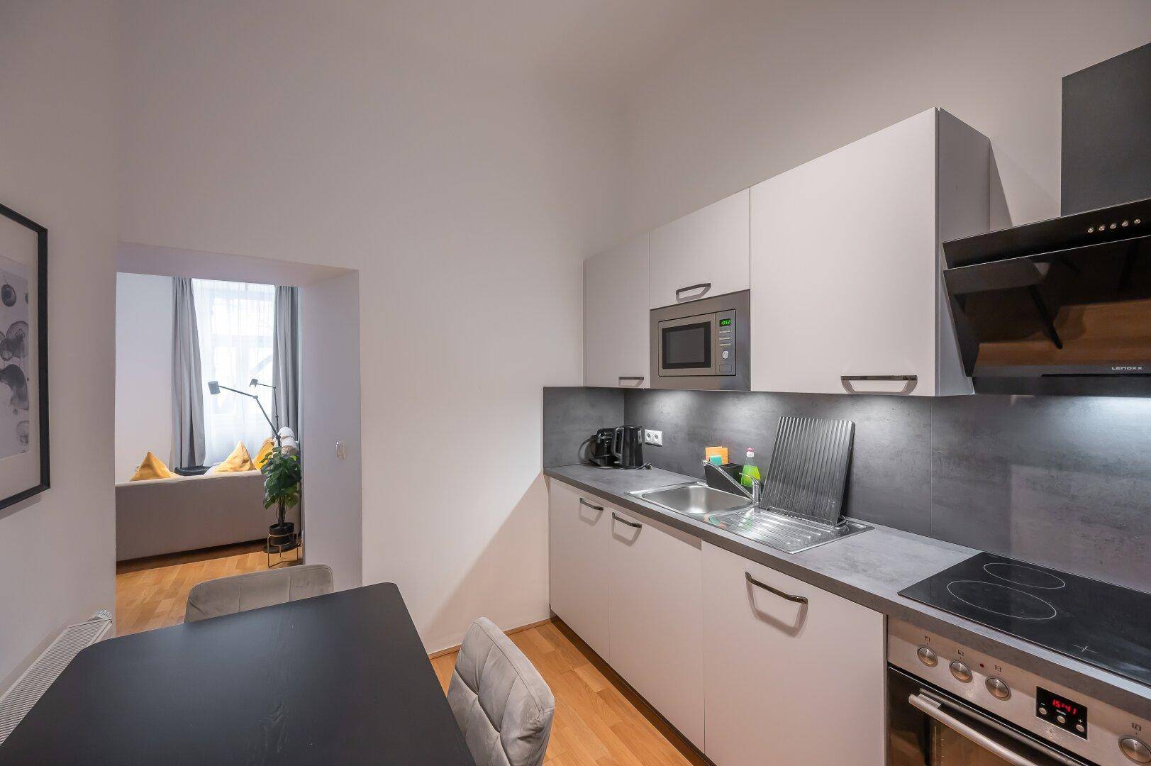 Funktionale Küche mit Essbereich und offenem Zugang zum Wohnzimmer.