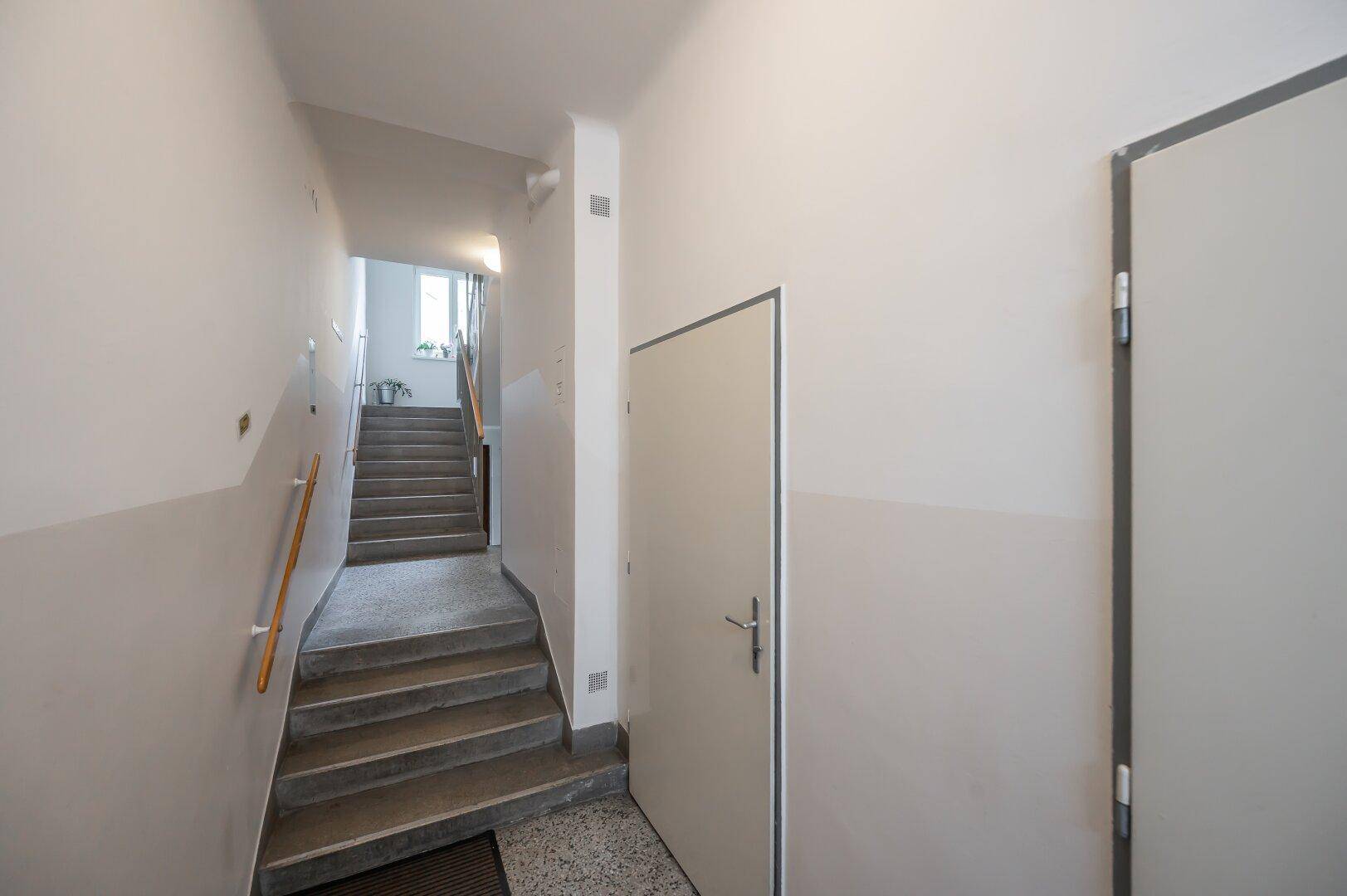 Treppenhaus mit robusten Stufen und Handläufen, das zu den oberen Stockwerken führt.