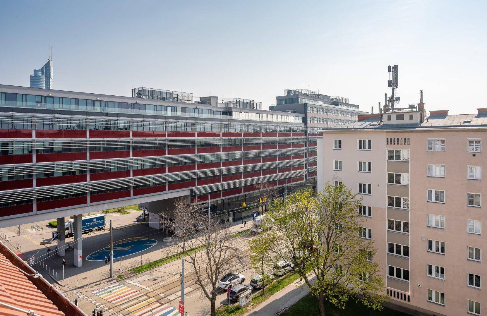 Stadtansicht mit modernen Bürogebäuden und belebter Straße.