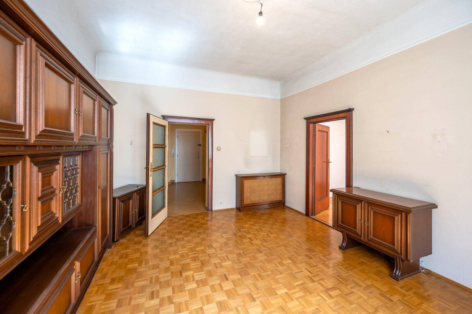 Heller Wohnbereich mit Parkett und traditionellen Holzmöbeln, ideal für eine klassische Einrichtung.