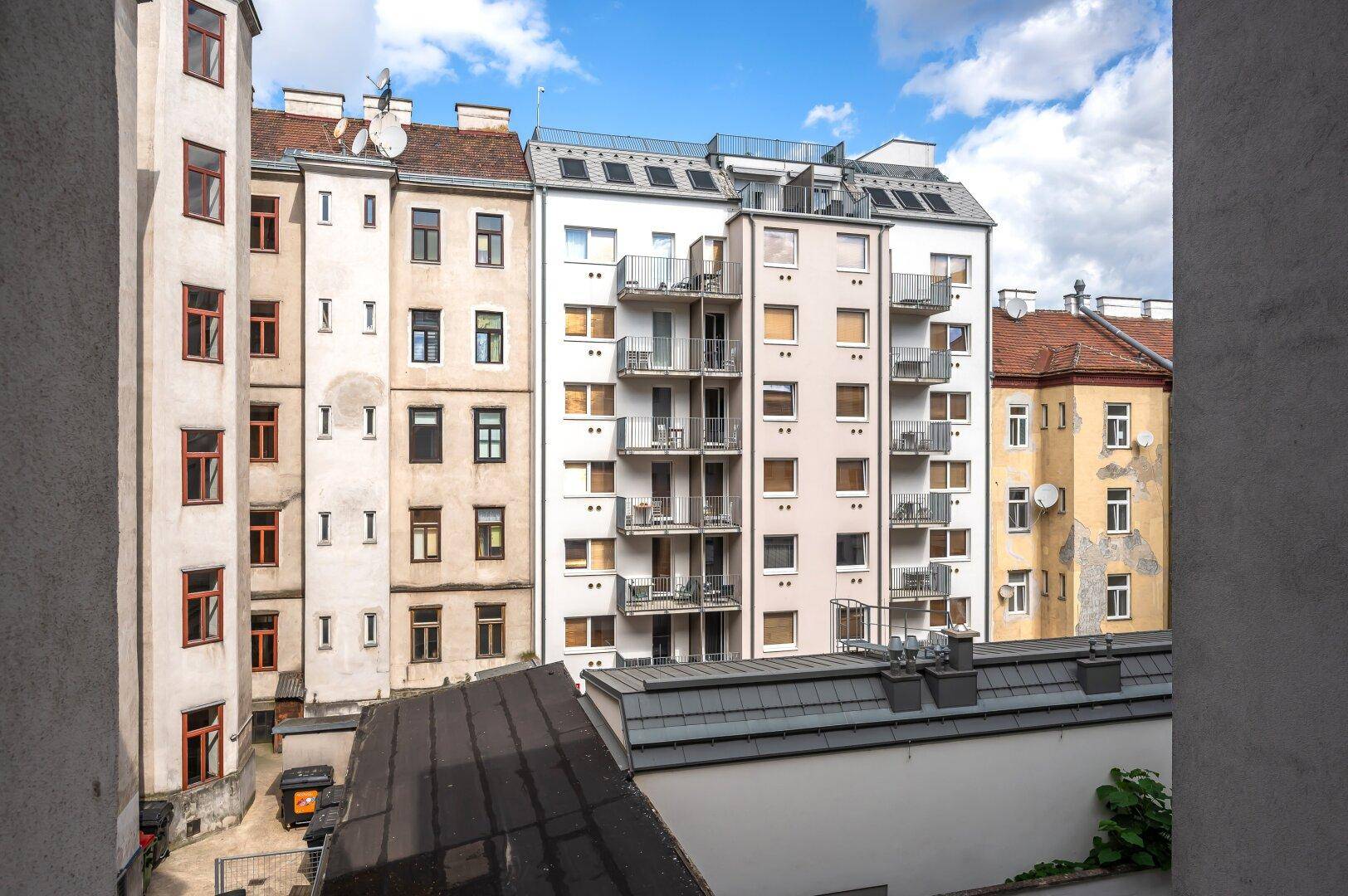 Ansicht mehrerer Wohngebäude mit Balkonen und unterschiedlichen Fassaden in urbaner Umgebung.