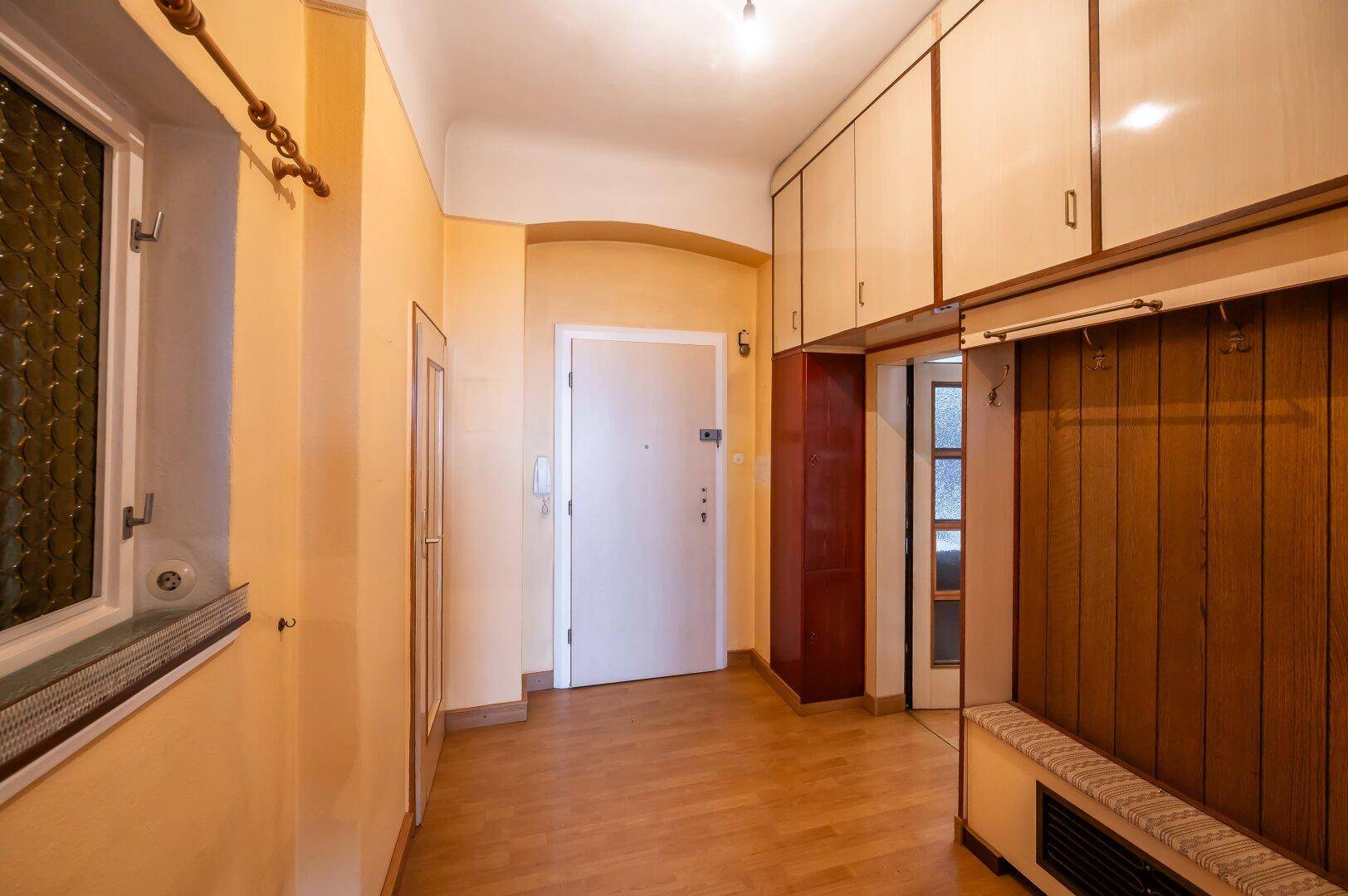 Geräumiger Flur mit Einbauschränken und Fenster, bietet viel Platz für Garderobe und Stauraum.