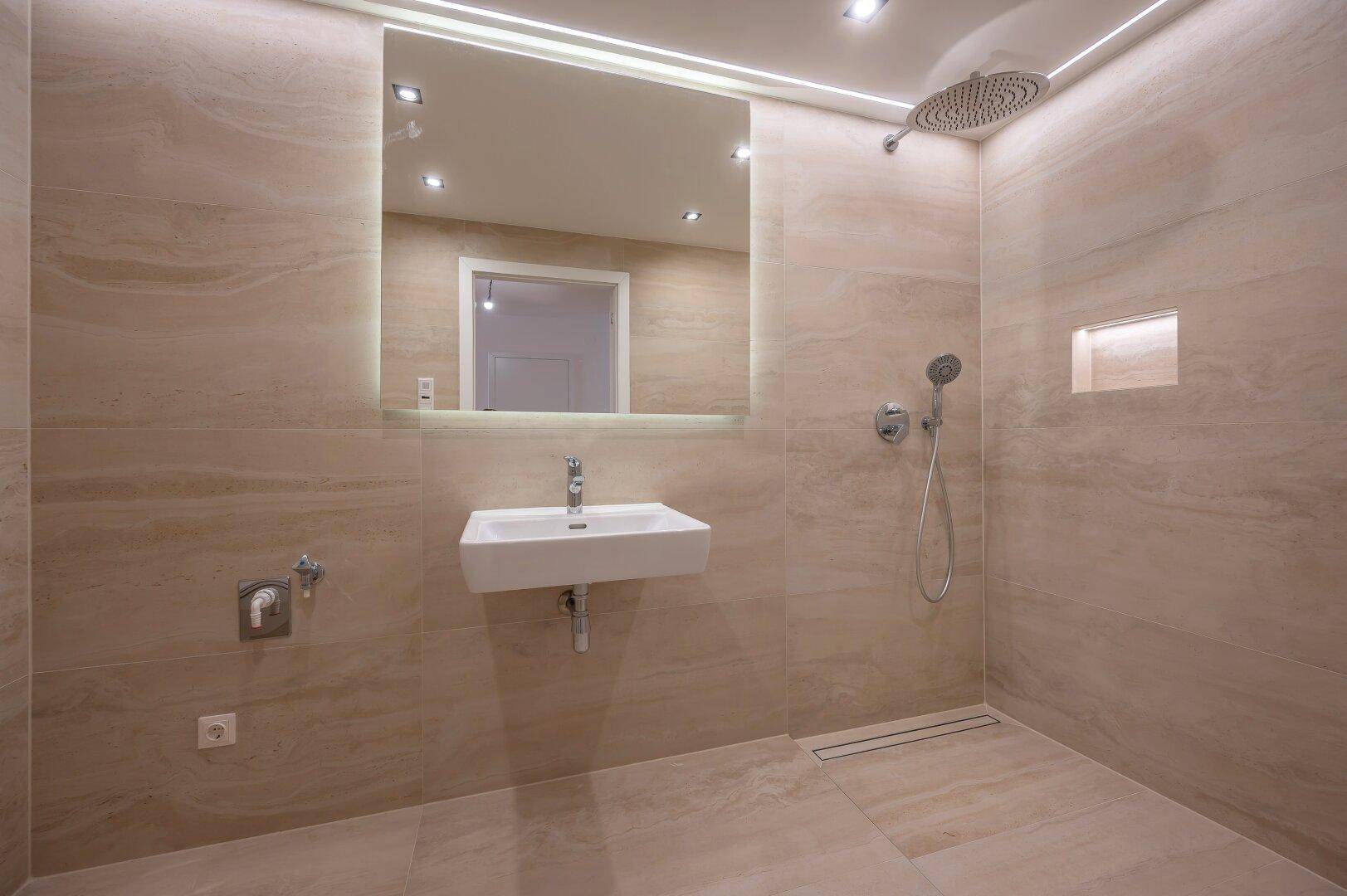 Elegantes Badezimmer mit begehbarer Dusche, Regendusche und modernem Waschbecken.