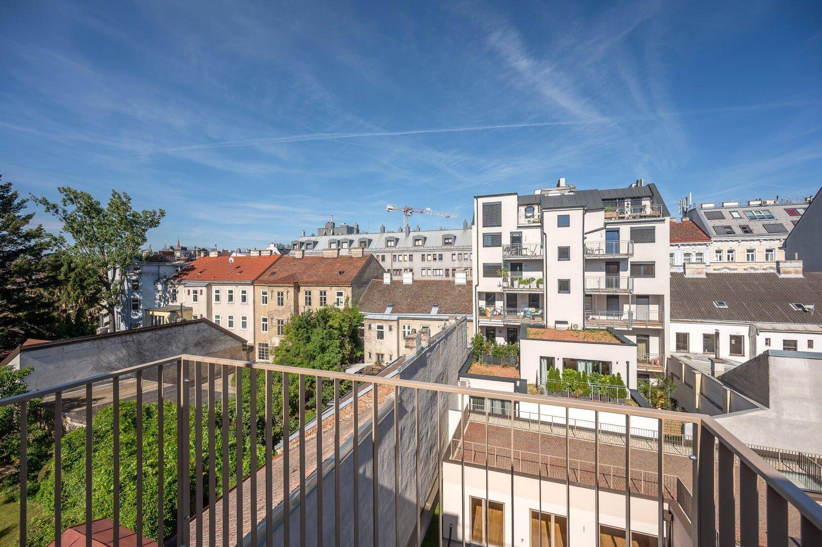 Sonniger Balkon mit weitem Blick über die Dächer der Stadt und die Umgebung.