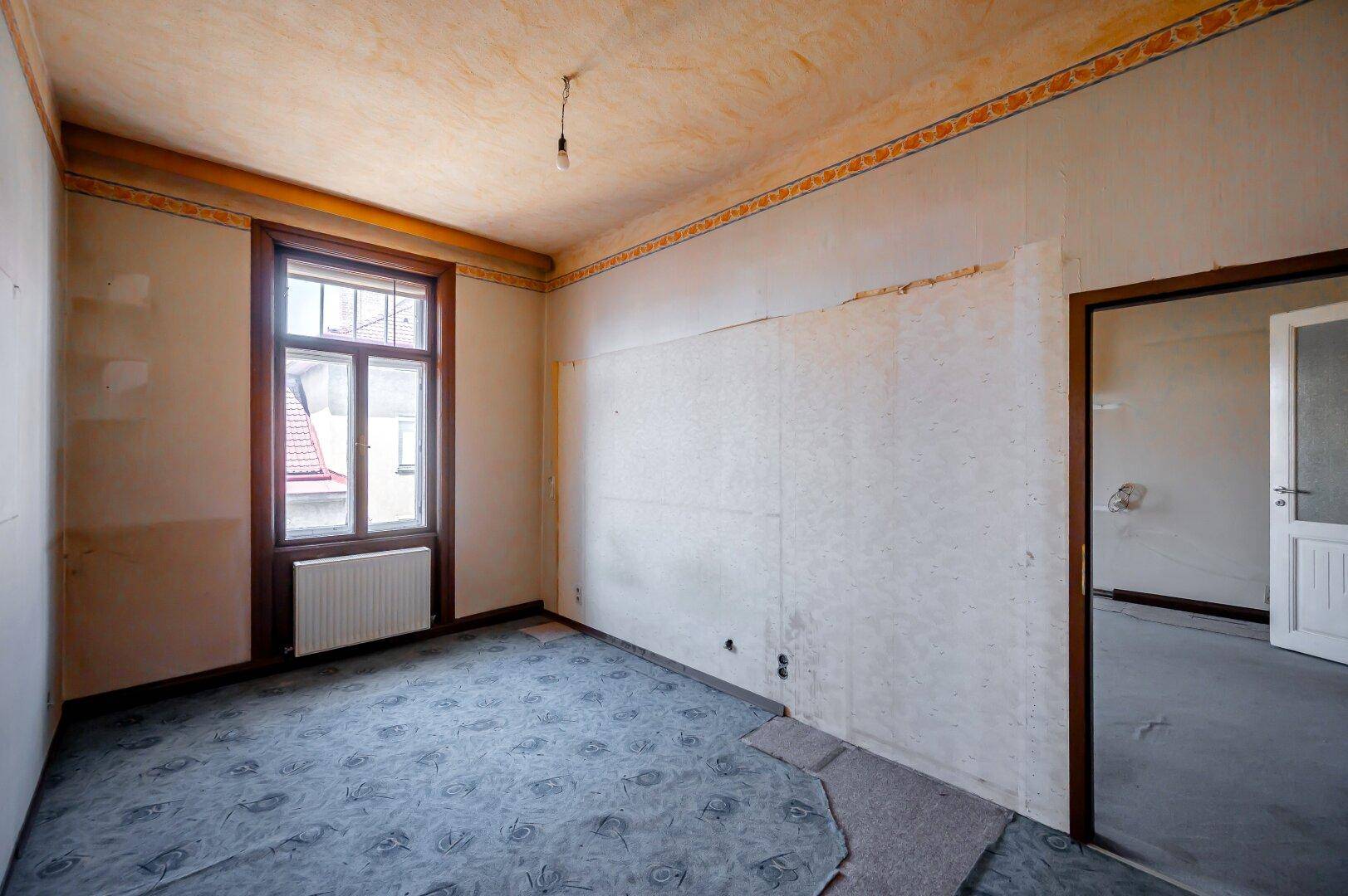 Helles Zimmer mit Teppichboden und einem großen Fenster, ideal für Schlafzimmer oder Büro.
