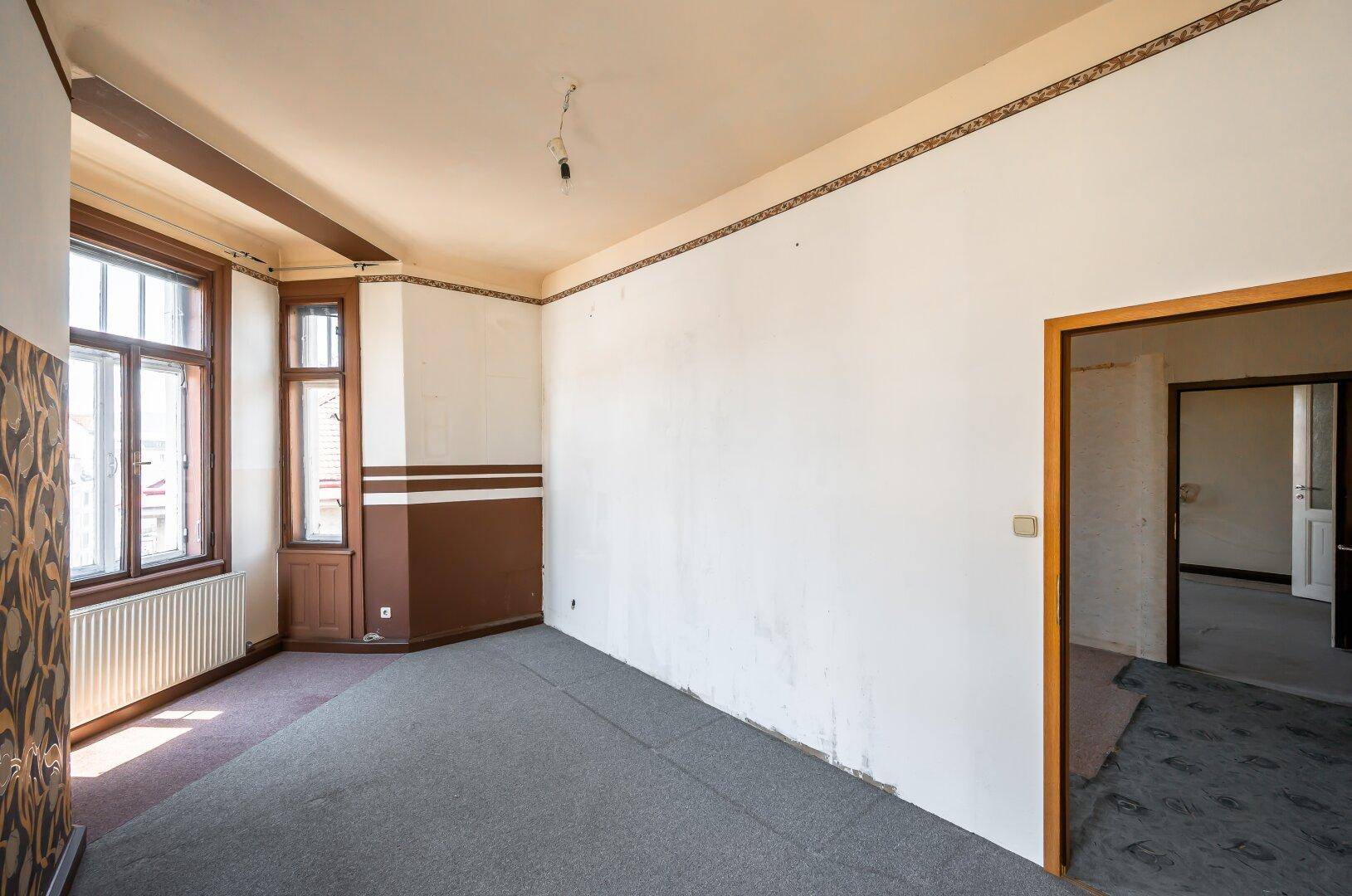 Unmöbliertes Zimmer mit Teppichboden und großen Fenstern, bereit für eine individuelle Gestaltung.